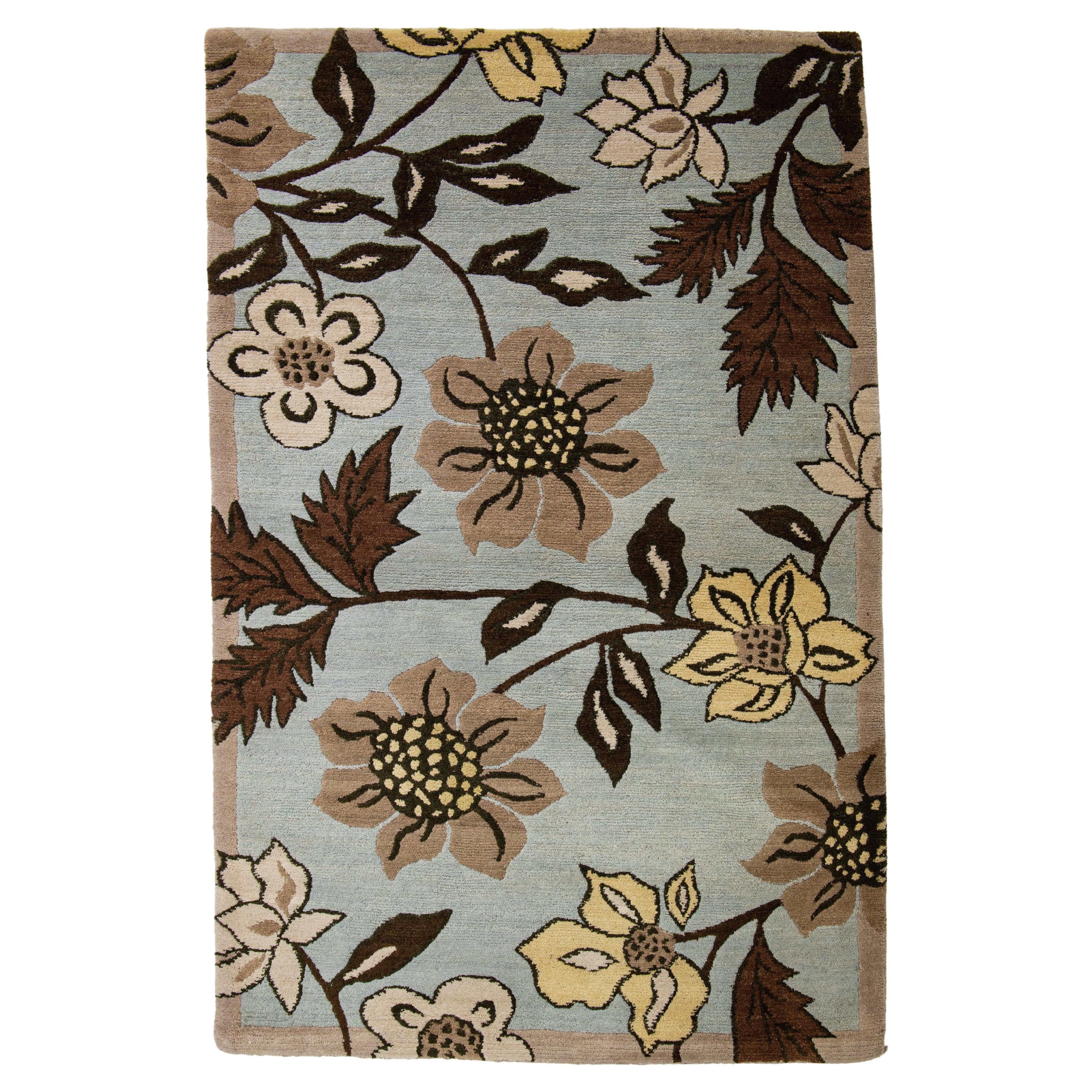 Blauer Übergangsteppich aus Wolle mit floralem Allover-Design