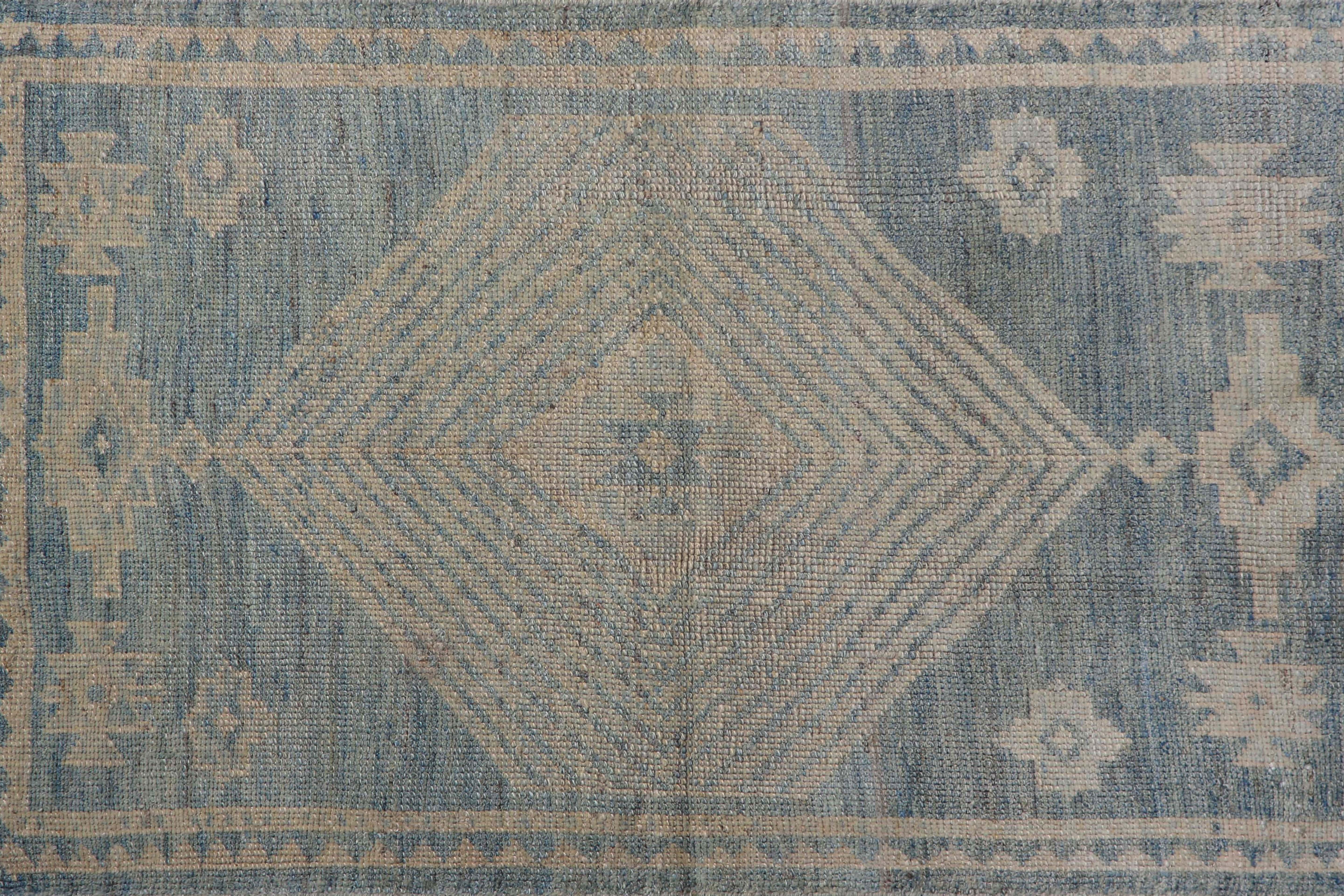 Introducing our exquisite handmade Turkish Oushak runner rug, measuring 3'0'' by 4'9''. This stunning rug features a beautiful blue background with light cream colors seamlessly woven into its traditional design. The small visible border blends