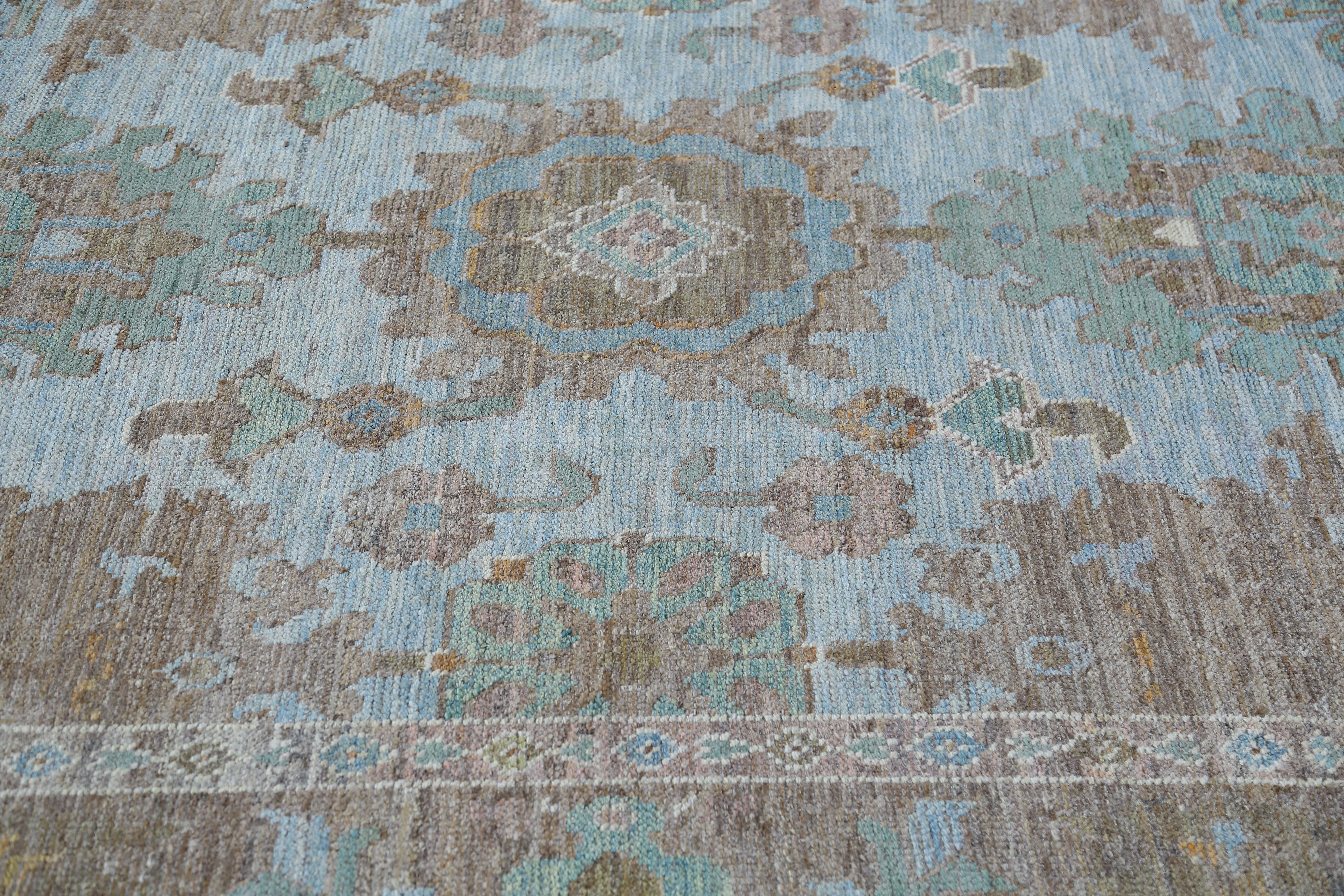 Our 7'10'' x 10'9'' rug is a gorgeous addition to any space. Handcrafted by skilled Turkish artisans using high-quality wool, this rug boasts a unique and captivating design that is sure to impress. With soft blue and neutral tones, this rug