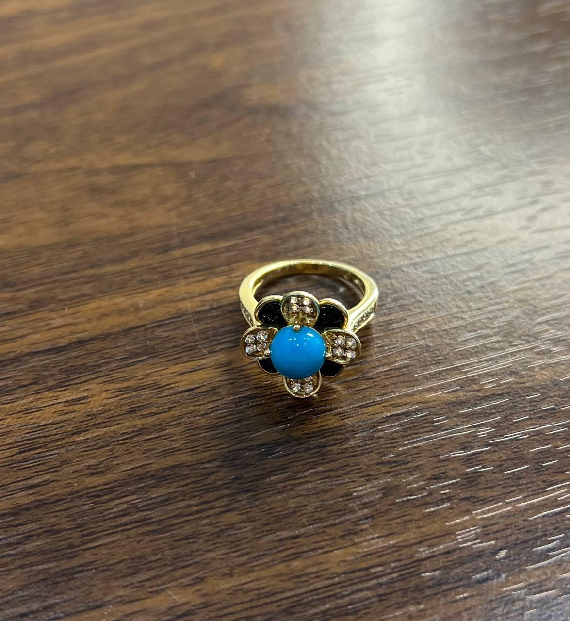 A striking and elegant ring featuring a central round turquoise stone of vivid blue color.

The ring is accented by small round brilliant-cut diamonds set around the turquoise in a floral pattern with black onyx corners.

Crafted in 14K yellow gold,
