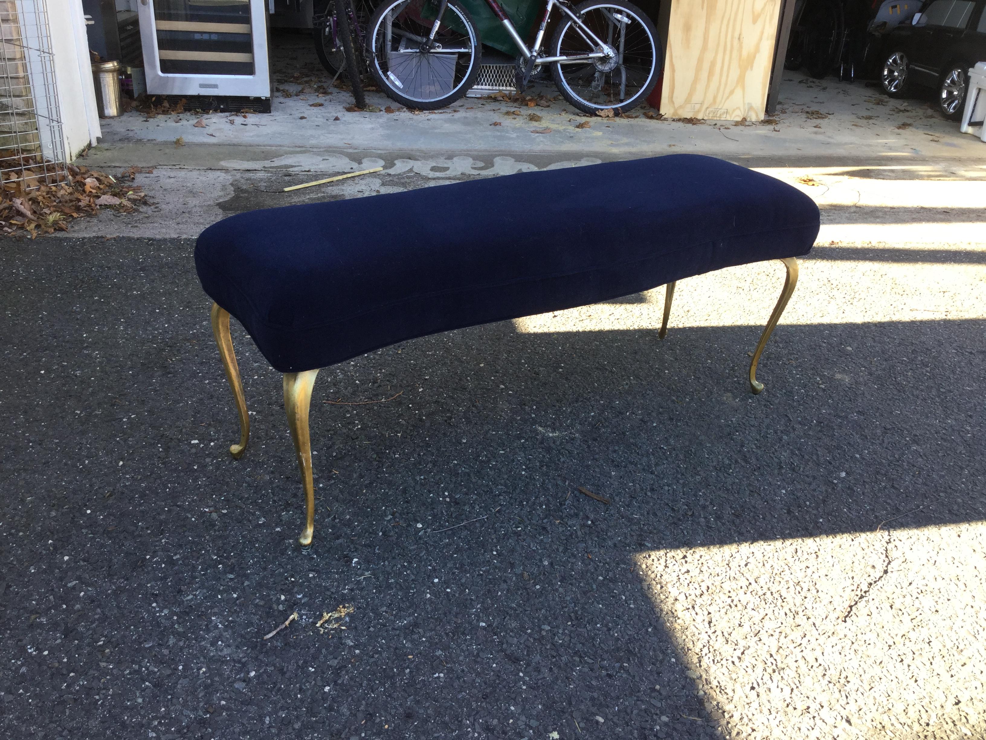 Elegant and practical, this blue velvet bench will enhance any bedroom or hallway. With brass curved legs, the bench is slightly scalloped and upholstered in a rich blue heavy velvet.
Excellent condition.