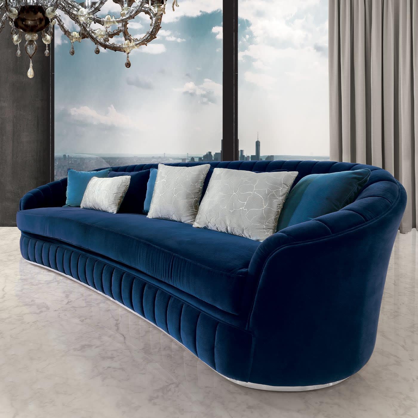 The generous size and plush character of this sofa suggests its placement inside wide interior decors ready to welcome refined guests. Featuring a generous memory foam padding enveloped by a precious blue velvet upholstery, it reveals its welcoming