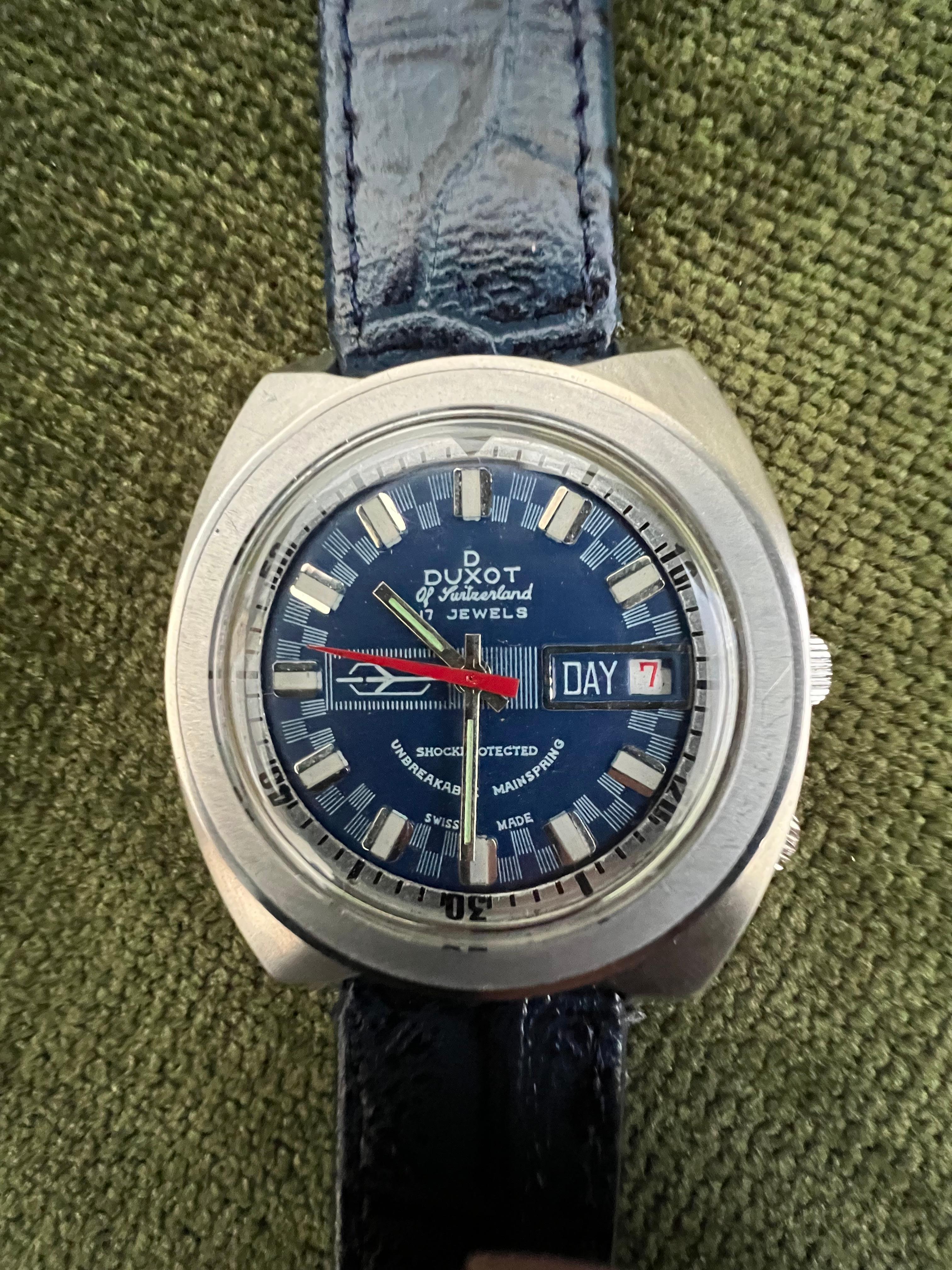 Blue 70s DUXOT OF SWITZERLAND 2 Dial - Airman STYLE CASE.
In amazing super condition. 
I love the 70s retro look on this sporty watch and I love the fact that it is in mint condition. 
CASE: LARGE ALL-STEEL CASE MEASURING A ROBUST 40mm ACROSS  NOT