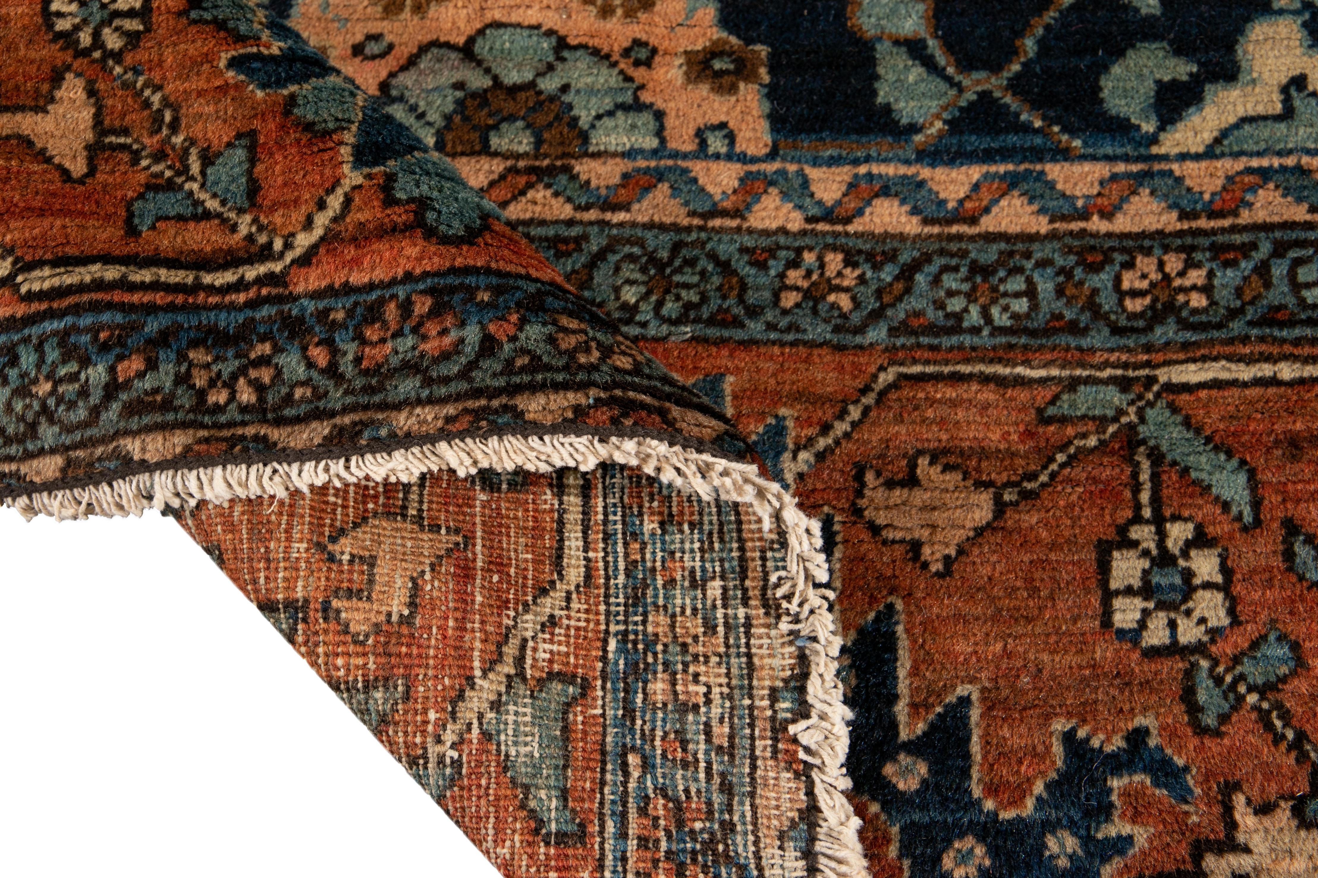 Beautiful vintage Persian Heriz hand knotted wool rug with a blue field. This rug has accents of brown, red, and beige in an all-over geometric medallion floral design. 

This rug measures 8'5