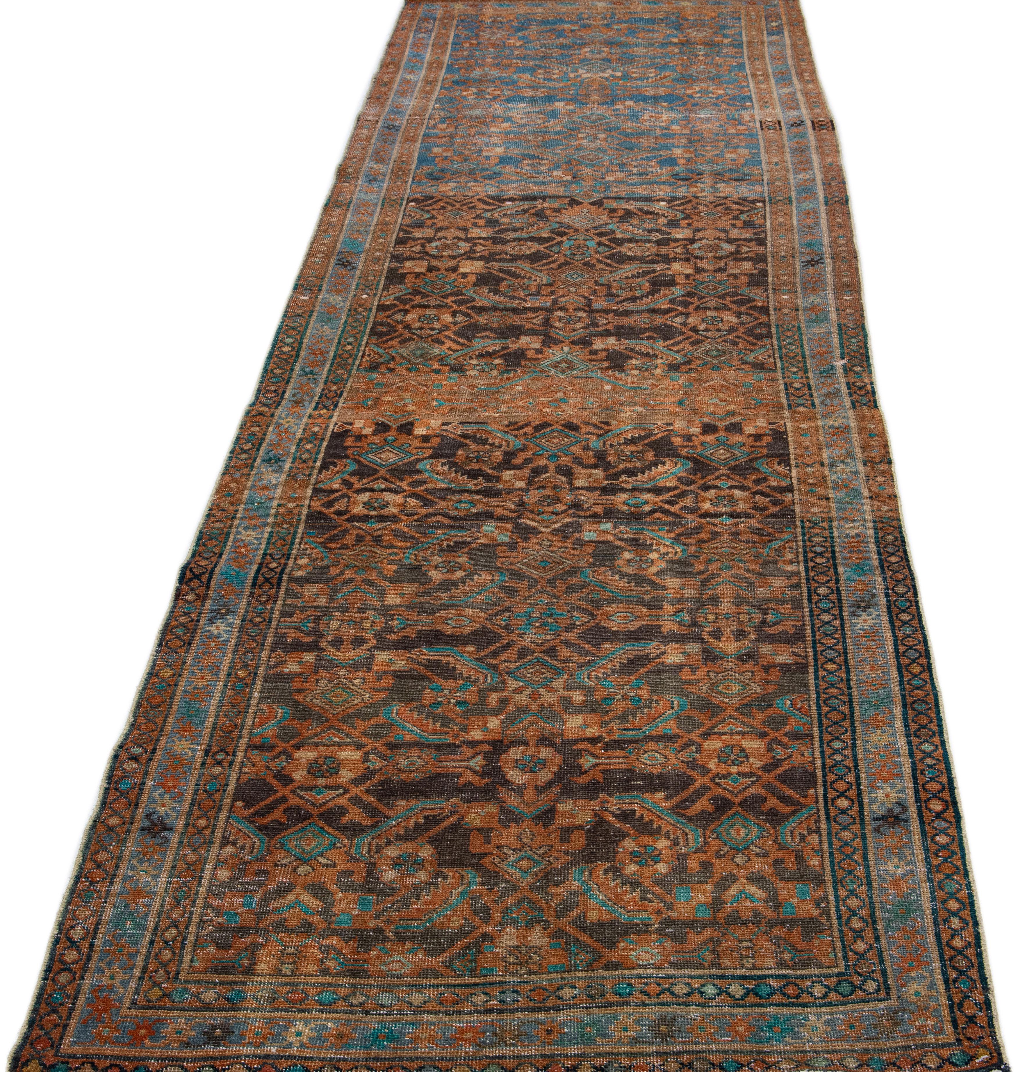 Beautiful vintage Malayer Persian runner rug with a blue field. This piece has brown, teal, and rust accents with an all-over geometric floral design. 

This rug measures 4'2