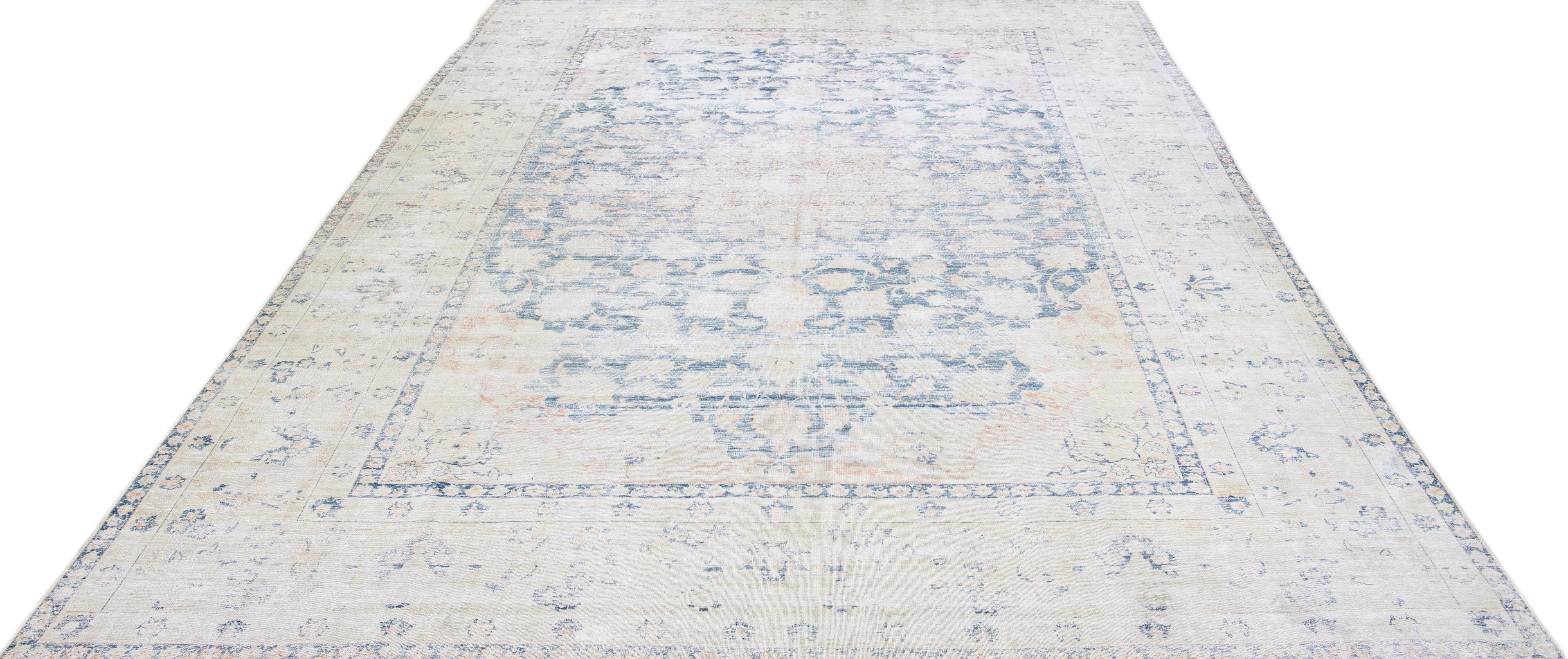 Beautiful antique Tabriz hand-knotted wool rug with a blue color field. This Persian rug has a beige frame with rust accents in a gorgeous all-over medallion design.

This rug measures: 9'8