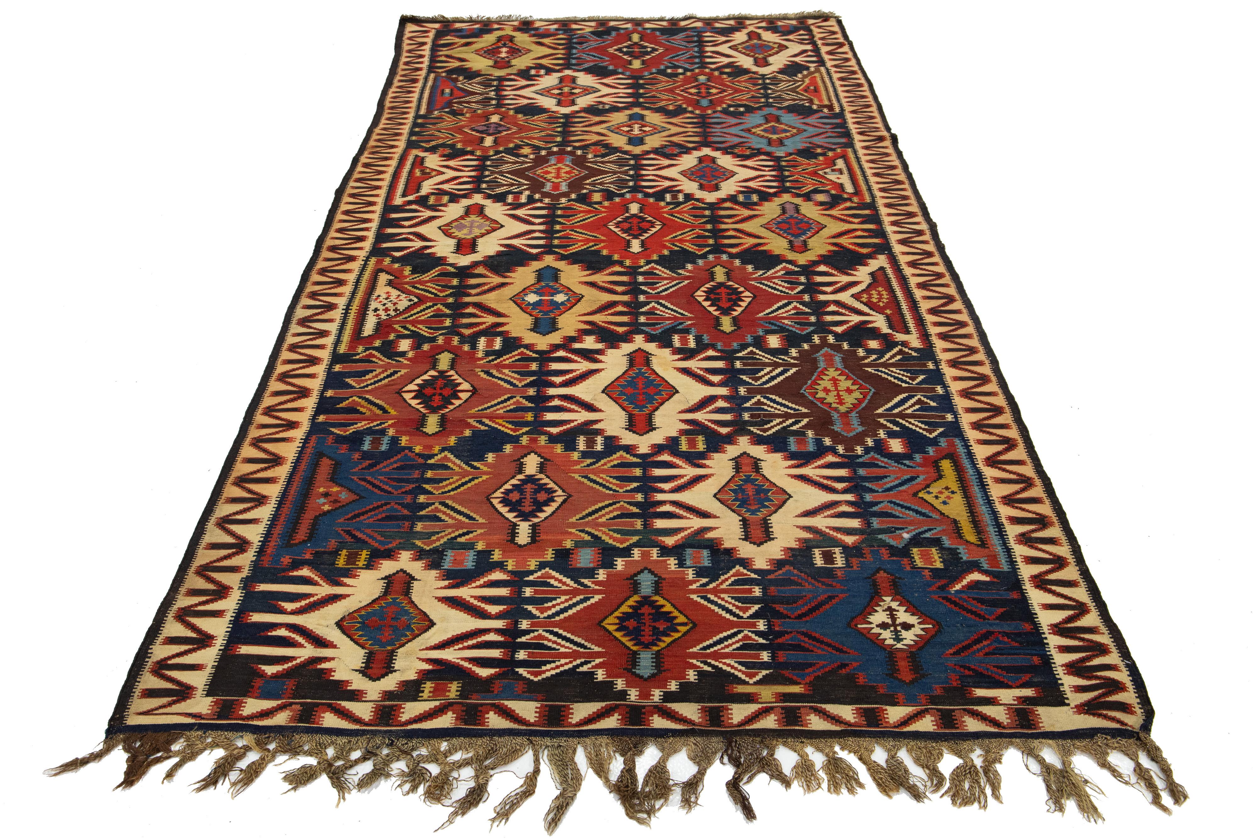Ein lebendiger, handgeknüpfter Kelim-Teppich aus Wolle mit geometrischem Muster auf marineblauem Hintergrund.

Dieser Teppich misst 5' x 10'5