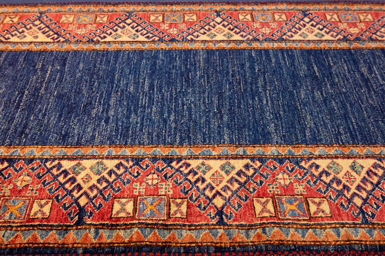 This is a blue vintage Uzbek Runner carpet and it has a beautiful minimalist design. This runner has a beautiful border design which encompasses geometric elements and add a touch of beauty to your house. This piece can add a charm to your space and