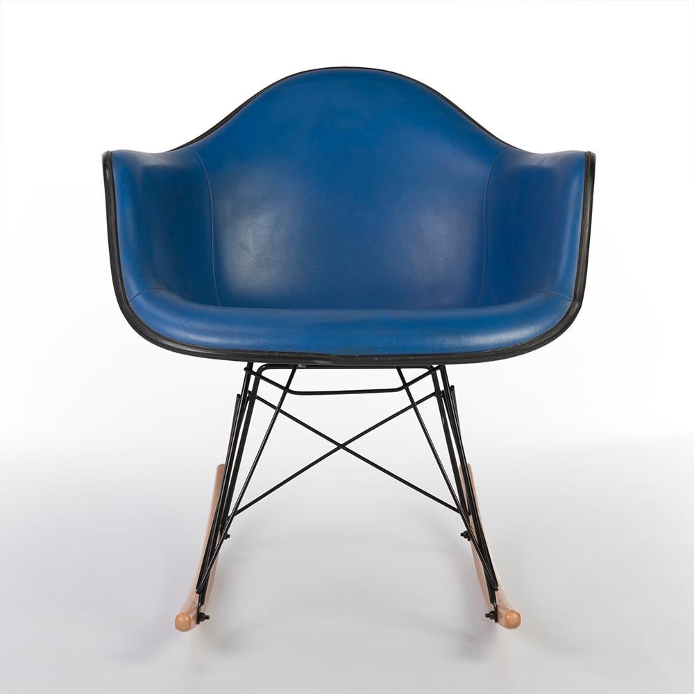 A great combination. The wonderful blue Eames fiberglass shell for Herman Miller has been finished in matching blue Naugahyde vinyl which does display signs of age with some small cuts in the vinyl finish. Sat upon its used, newer, light RAR rocking