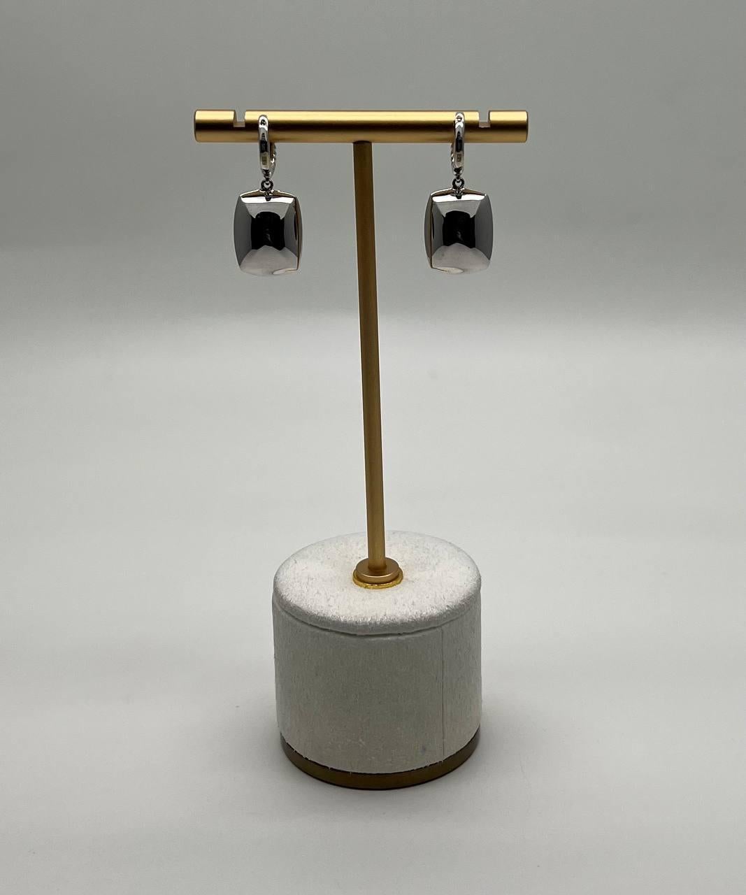 These stunning earrings feature a rectangular blue chalcedony set in a white gold frame. The earrings are designed with a twisted metal detail at the top, adding a touch of sophistication. 14K White Gold. Natural Gemstones and Diamonds.