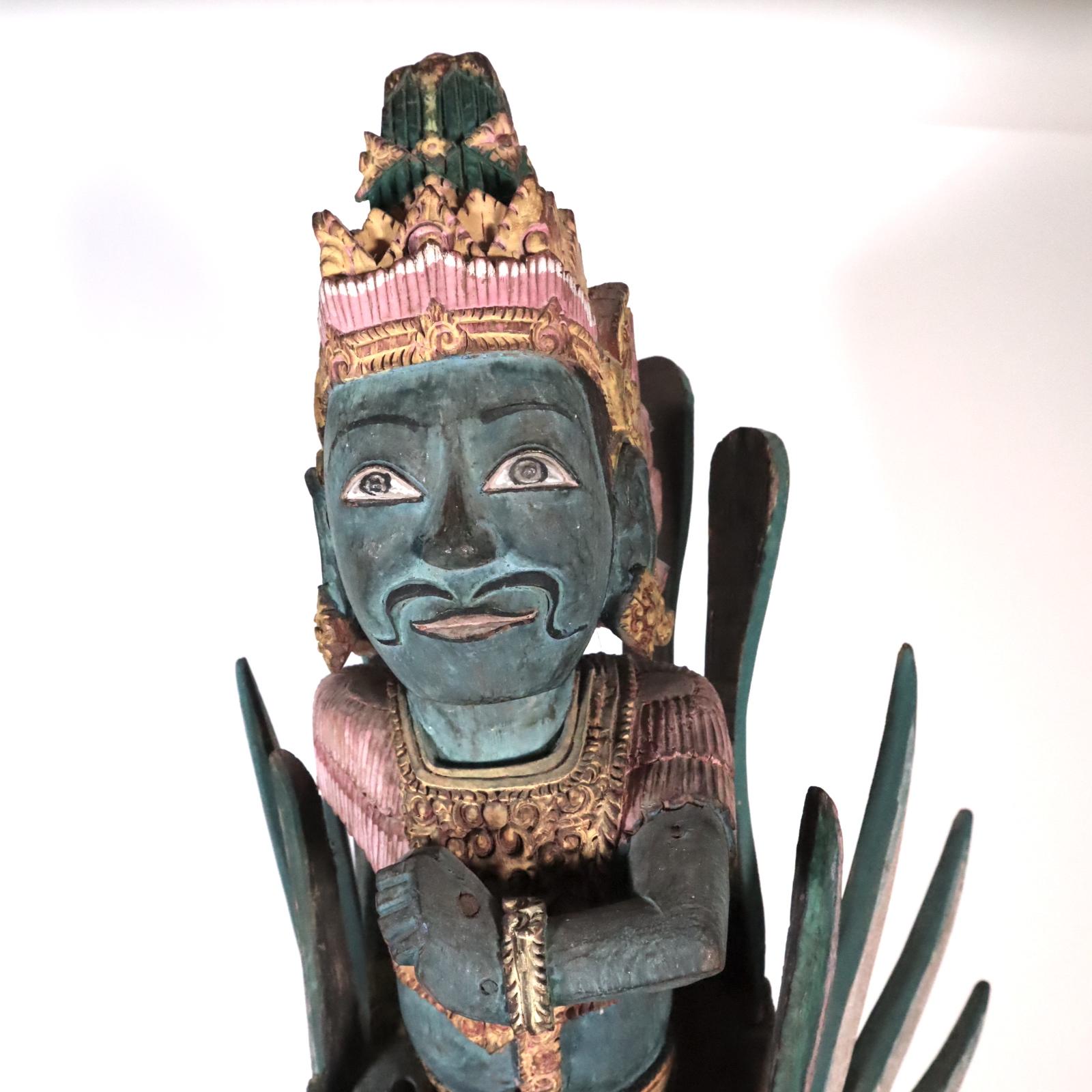 Vishnu riding Garuda, painted wood, from Bali, Indonesia, late 20th century. Carved form one piece of hardwood with the wing and tail feathers attached with nails.
As traditional, Vishnu is a blue color. He leans forward with an intense but benign