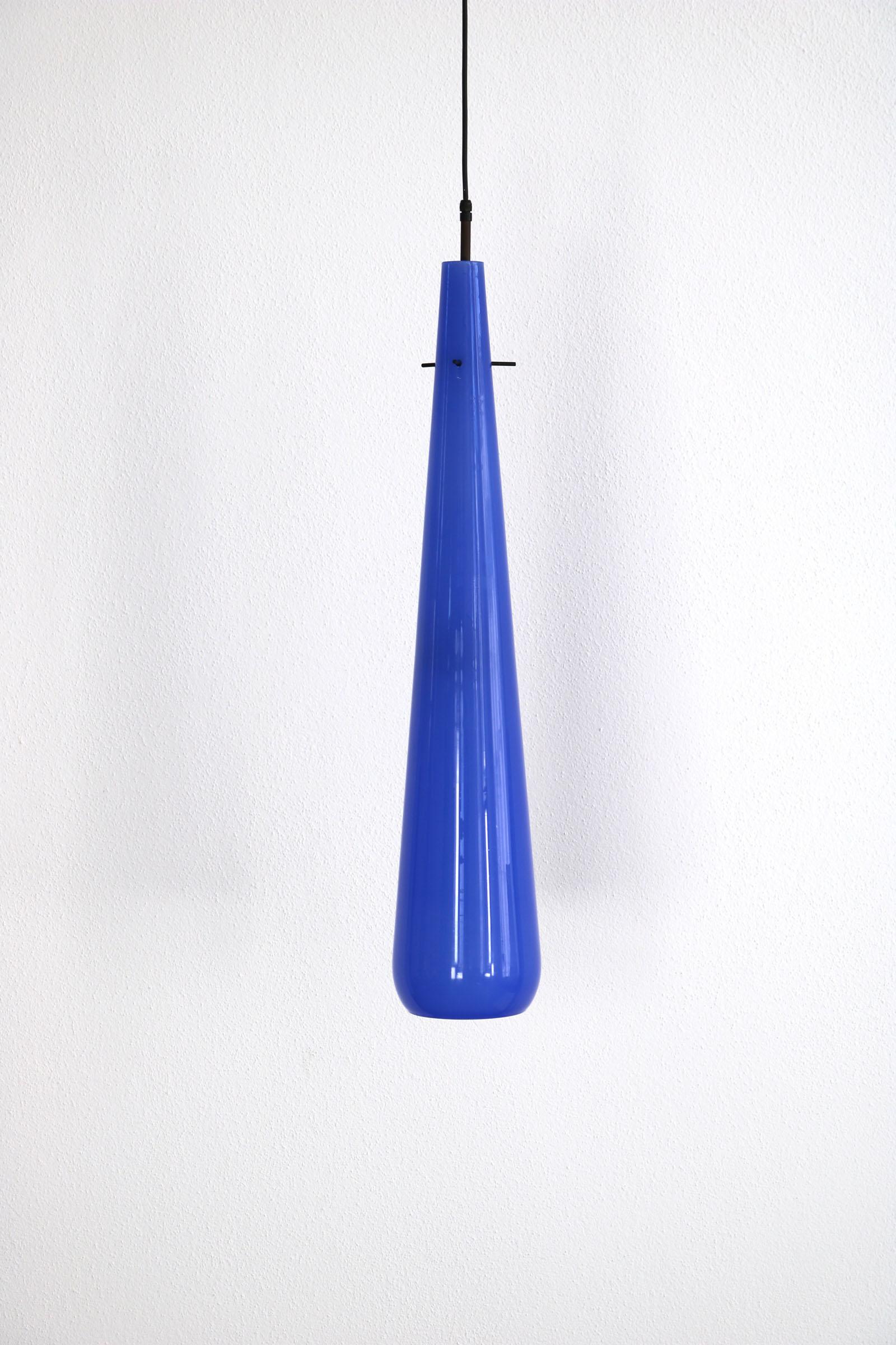 This Italian glass lamp was manufactured by Vistosi in 1950s. It is made of beautiful blue murano glass and hangs tear-shaped from the ceiling. The inside of the lamp is white. The lamp is in good Vinatge condition.