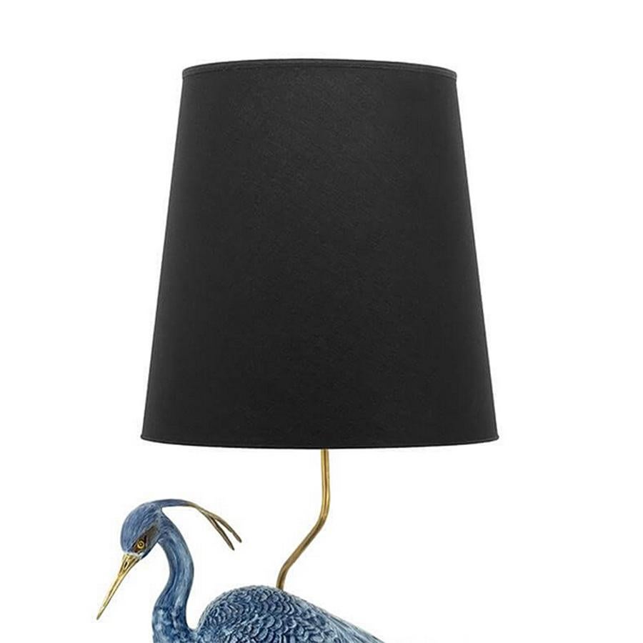 Table lamp blue wading bird with heron sculpture
in porcelain with solid brass legs and yable lamp
rods. Including a black sahed. 1 bulb, lamp holder 
type E27, max 40 watt, bulb not included.
Also available with white shade on request.