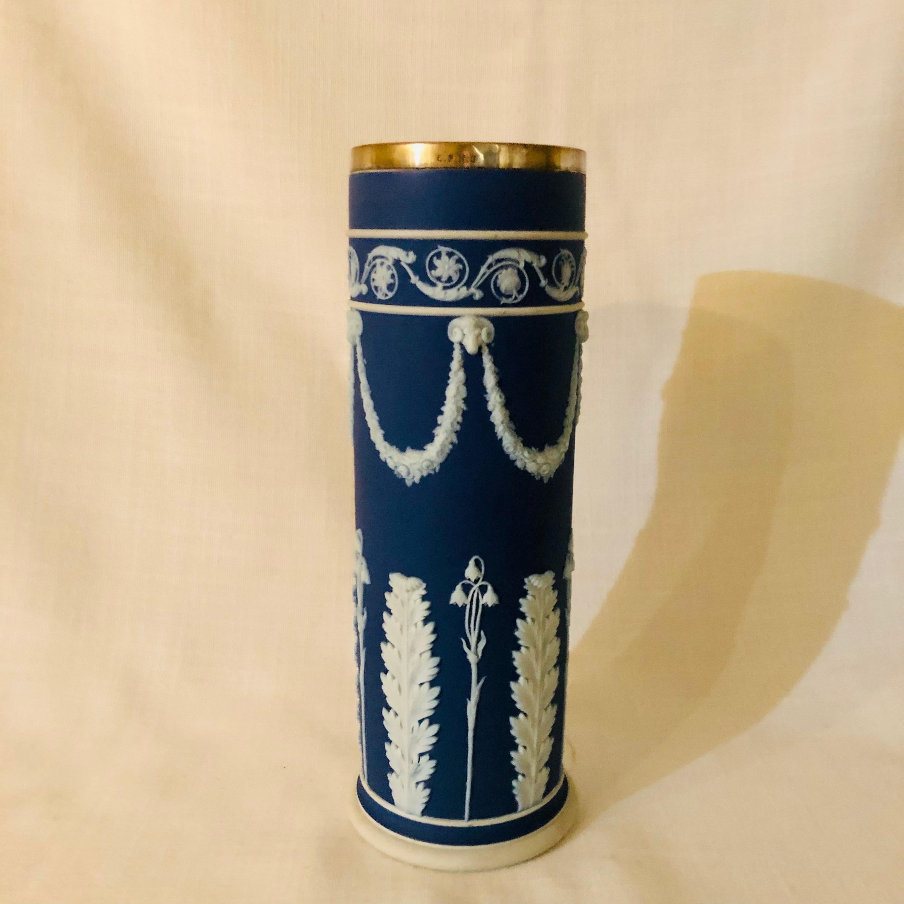 I want to offer you this antique Wedgwood dark blue jasperware vase decorated with rams heads and lilies of the valley with a silver plated rim on top. This decoration is one of my favorite jasperware decorations, as I personally love lilies of the