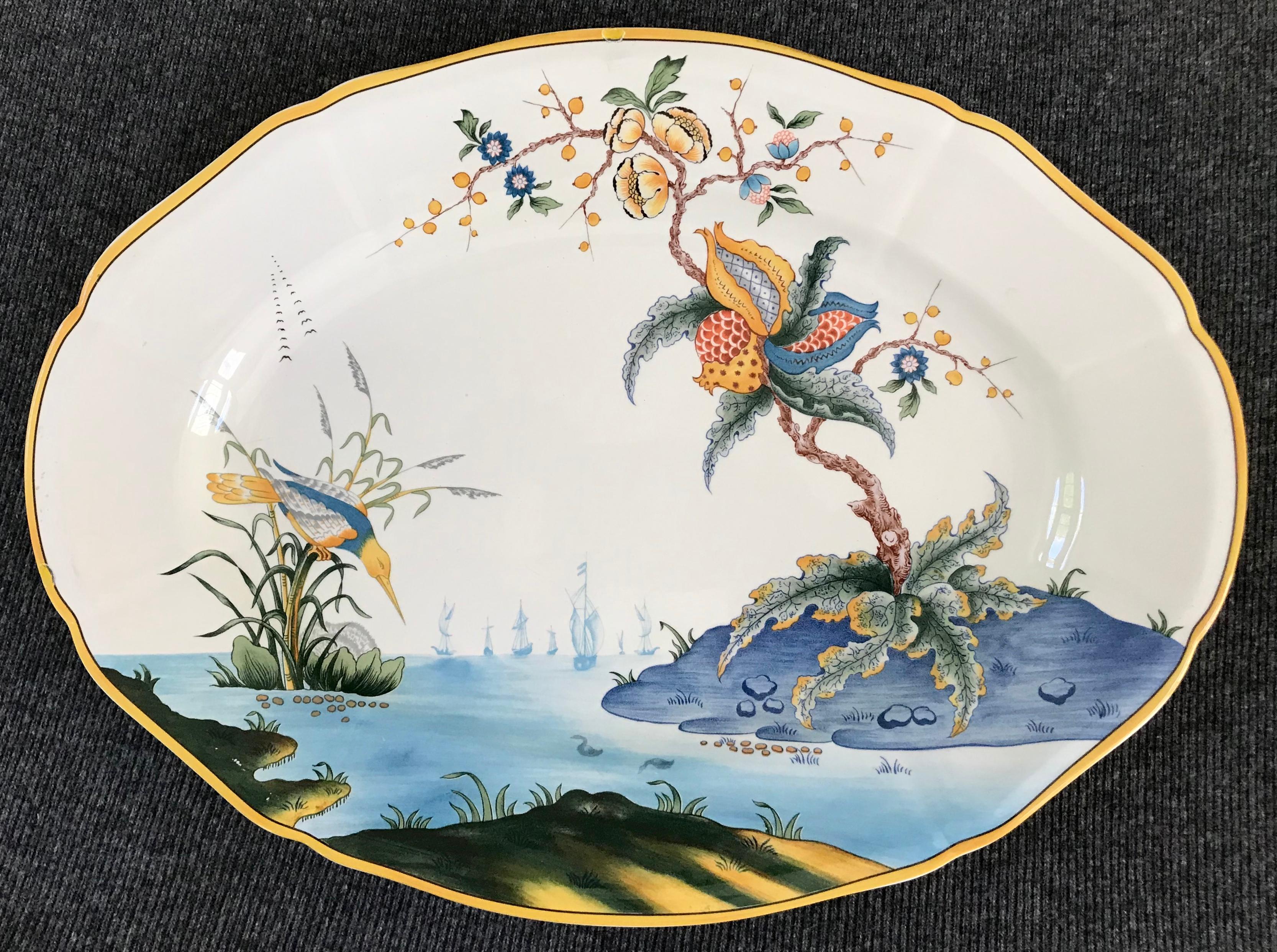 Blue, white and yellow bird platter. Vintage twentieth century platter with modern chinoiserie large scale flowers and exotic long billed rail bird in blues and greens and yellow gold border. Two small chips to rim; markings for Gien. France, 20th