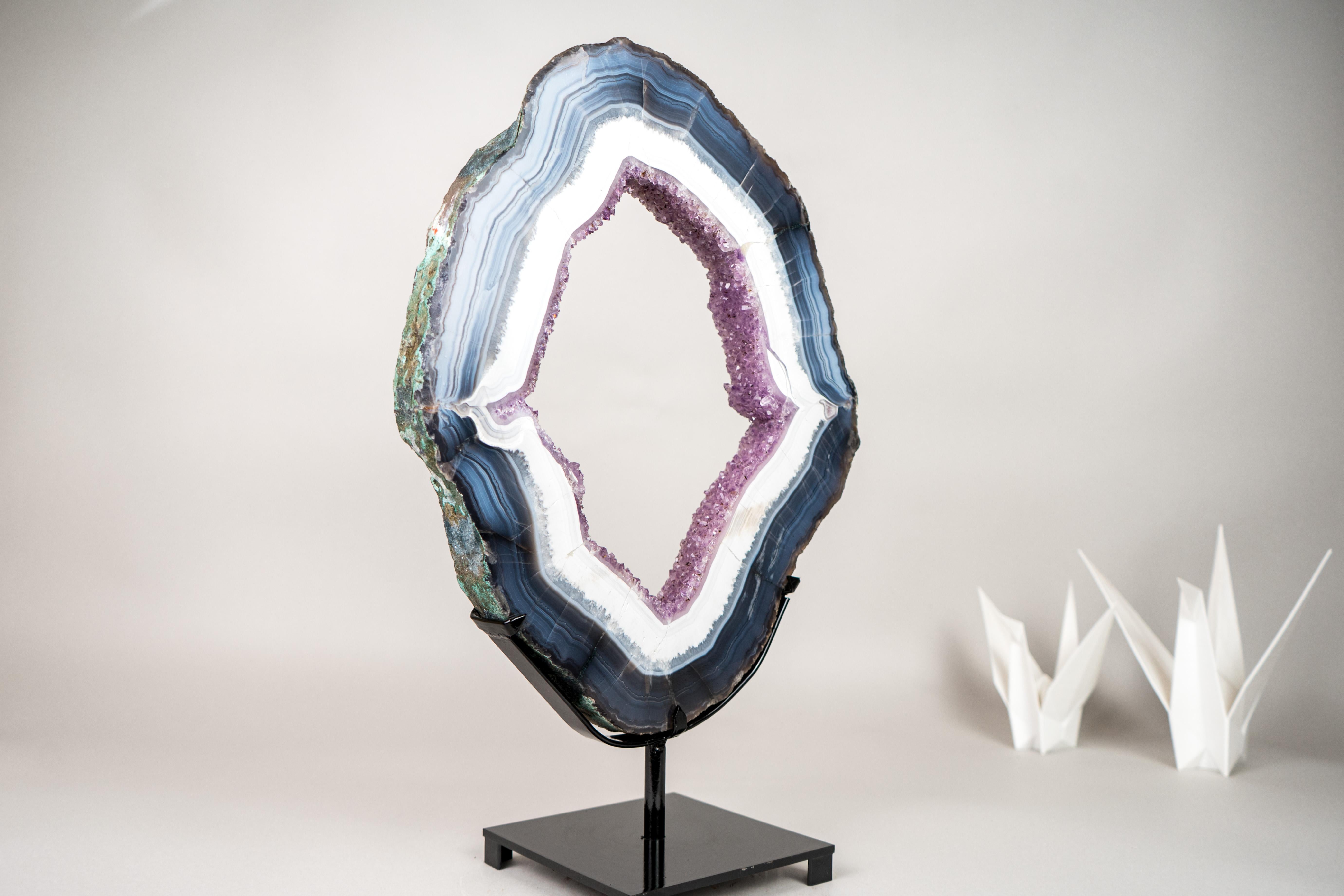 White and Blue Lace Agate Geode Slice with Rose Purple Amethyst Druzy

▫️ Description

What began as an ethically sourced agate geode was transformed when a slice was cut, bringing this banded agate geode slice to life and revealing a true work of