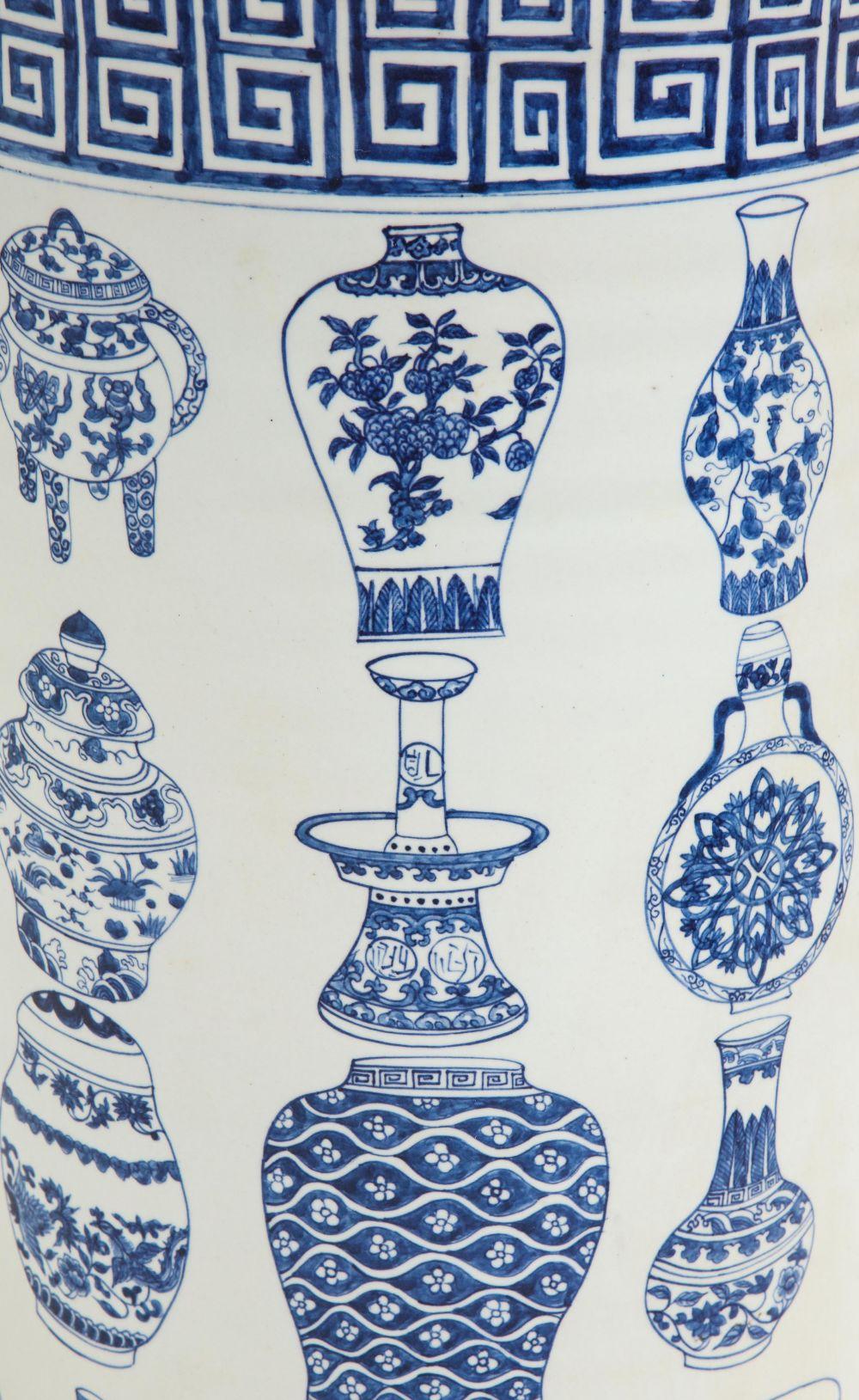 Of cylindrical form; with meander borders; decorated with an assortment of different blue and white Chinese vases.