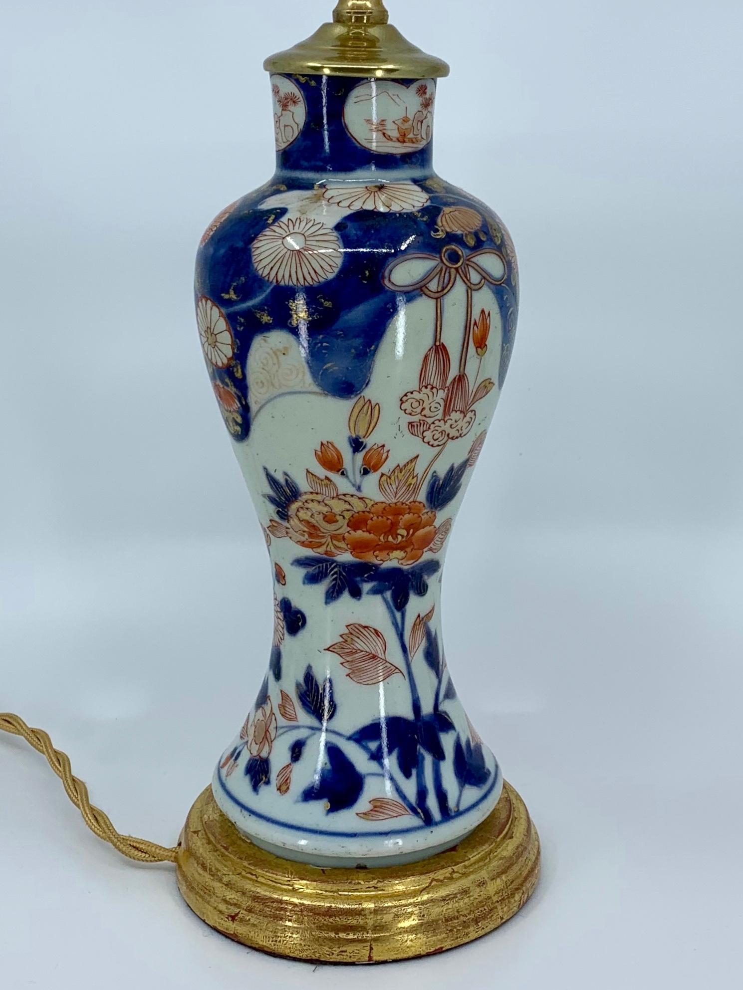 Chinois Lampe en porcelaine bleue, blanche, rouge et dorée sur base en bois doré en vente