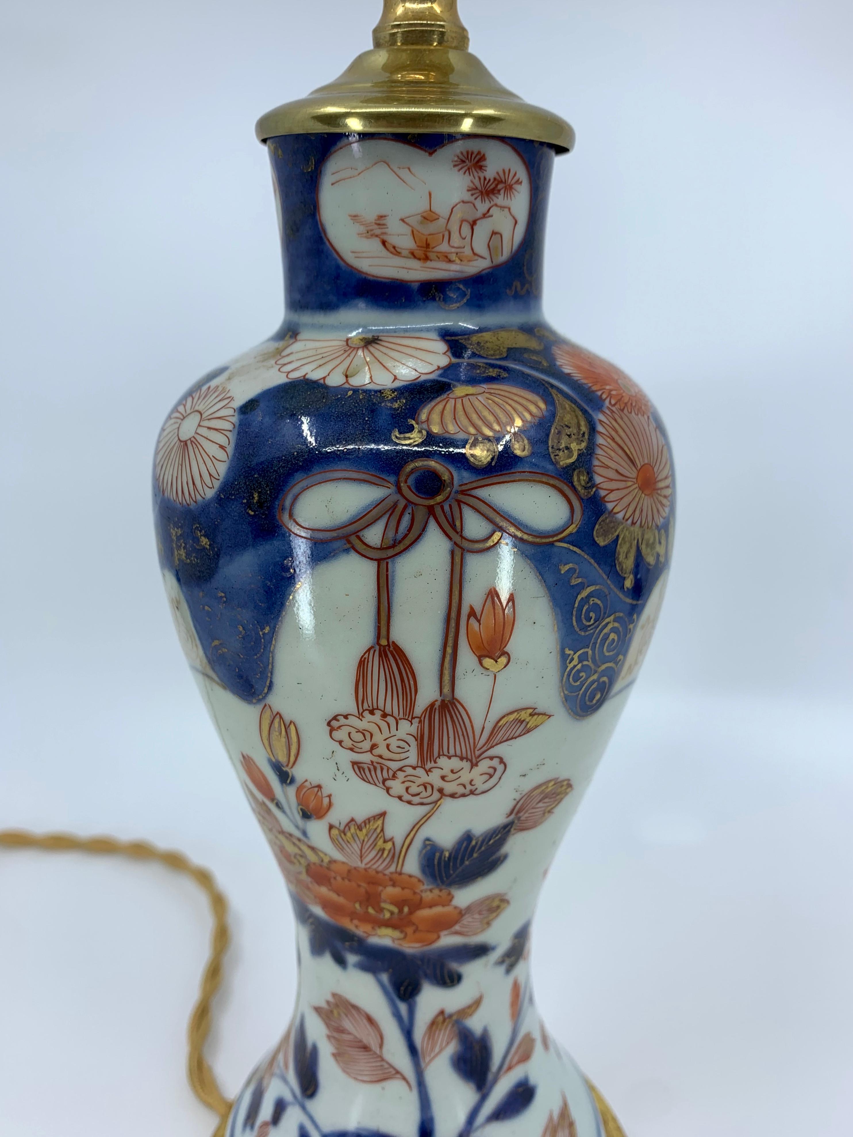 Lámpara de porcelana azul, blanca, roja y dorada sobre base de madera dorada siglo XIX en venta