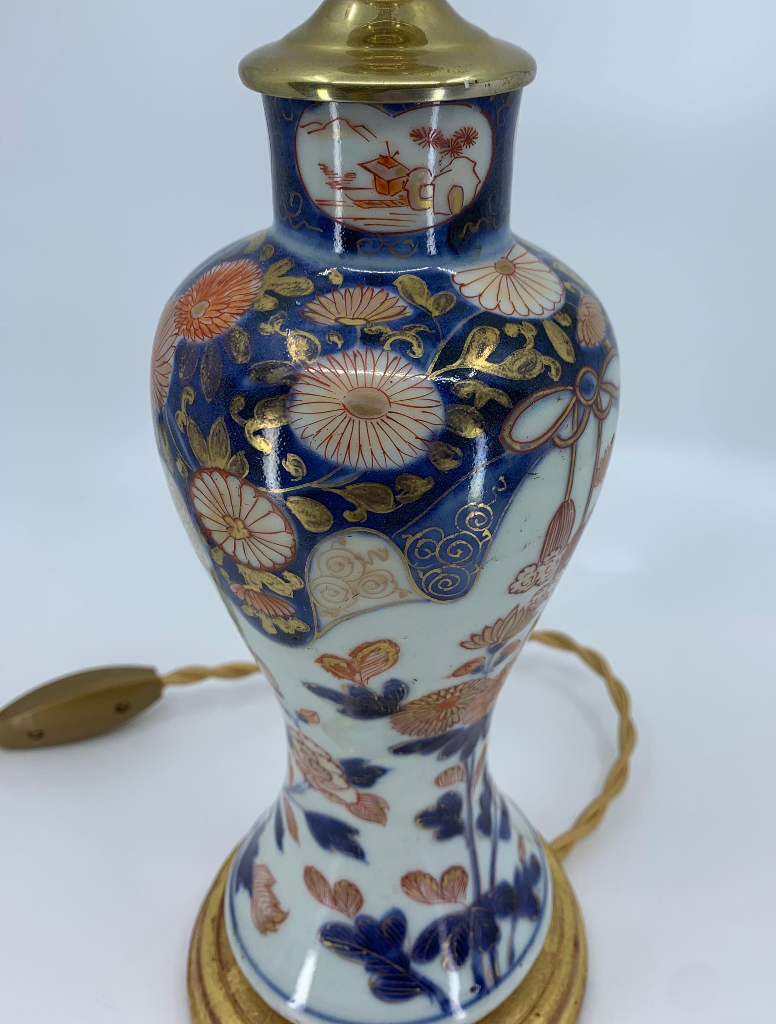 Porcelaine Lampe en porcelaine bleue, blanche, rouge et dorée sur base en bois doré en vente