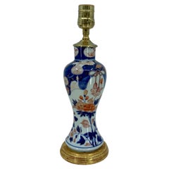 Lampe en porcelaine bleue, blanche, rouge et dorée sur base en bois doré