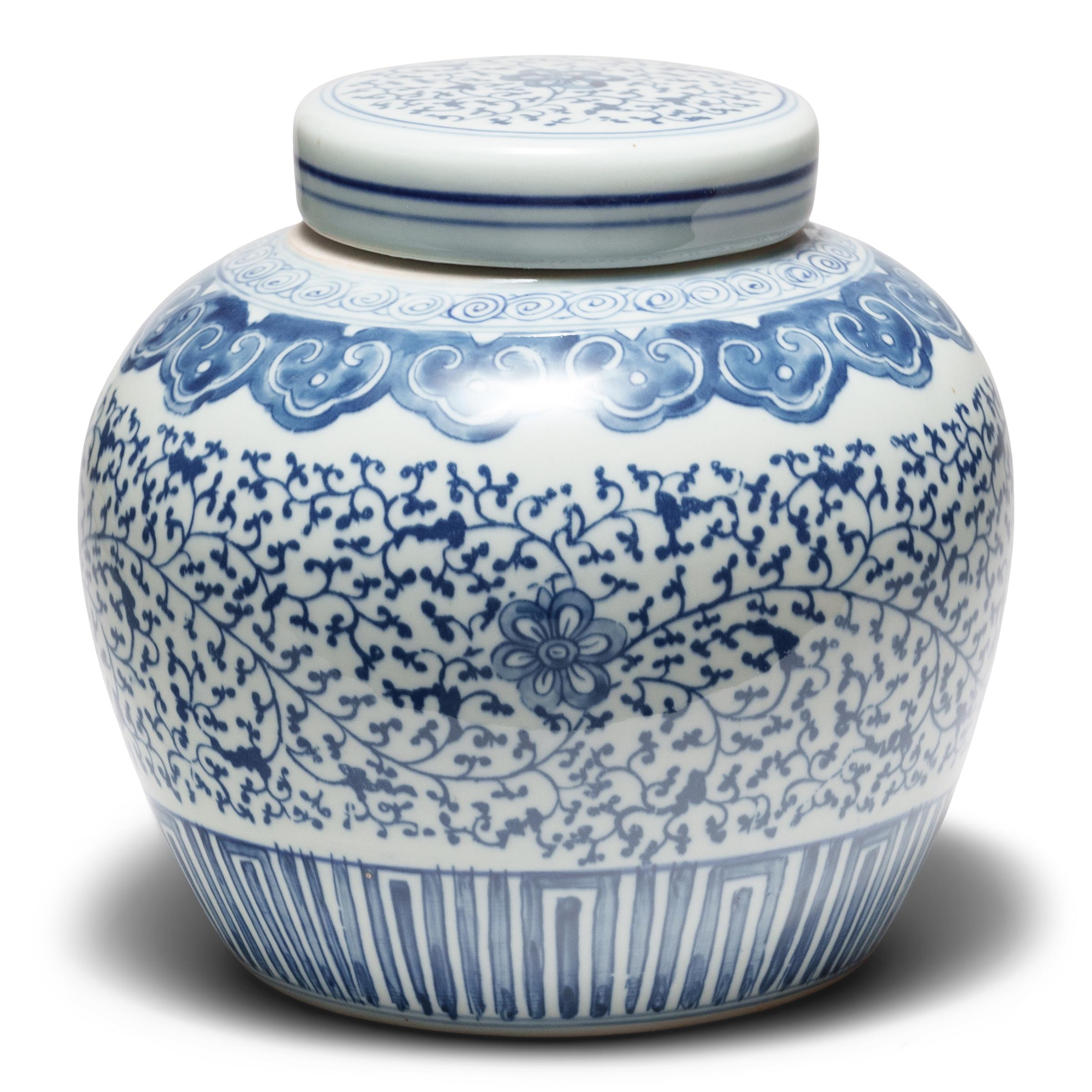 Ce pot à gingembre rond en porcelaine est brillamment émaillé dans le style bleu et blanc. Combinant le travail au pochoir et l'ombrage brossé à la main, les côtés et le couvercle sont animés d'un motif de vignes et de fleurs qui s'étend sur toute