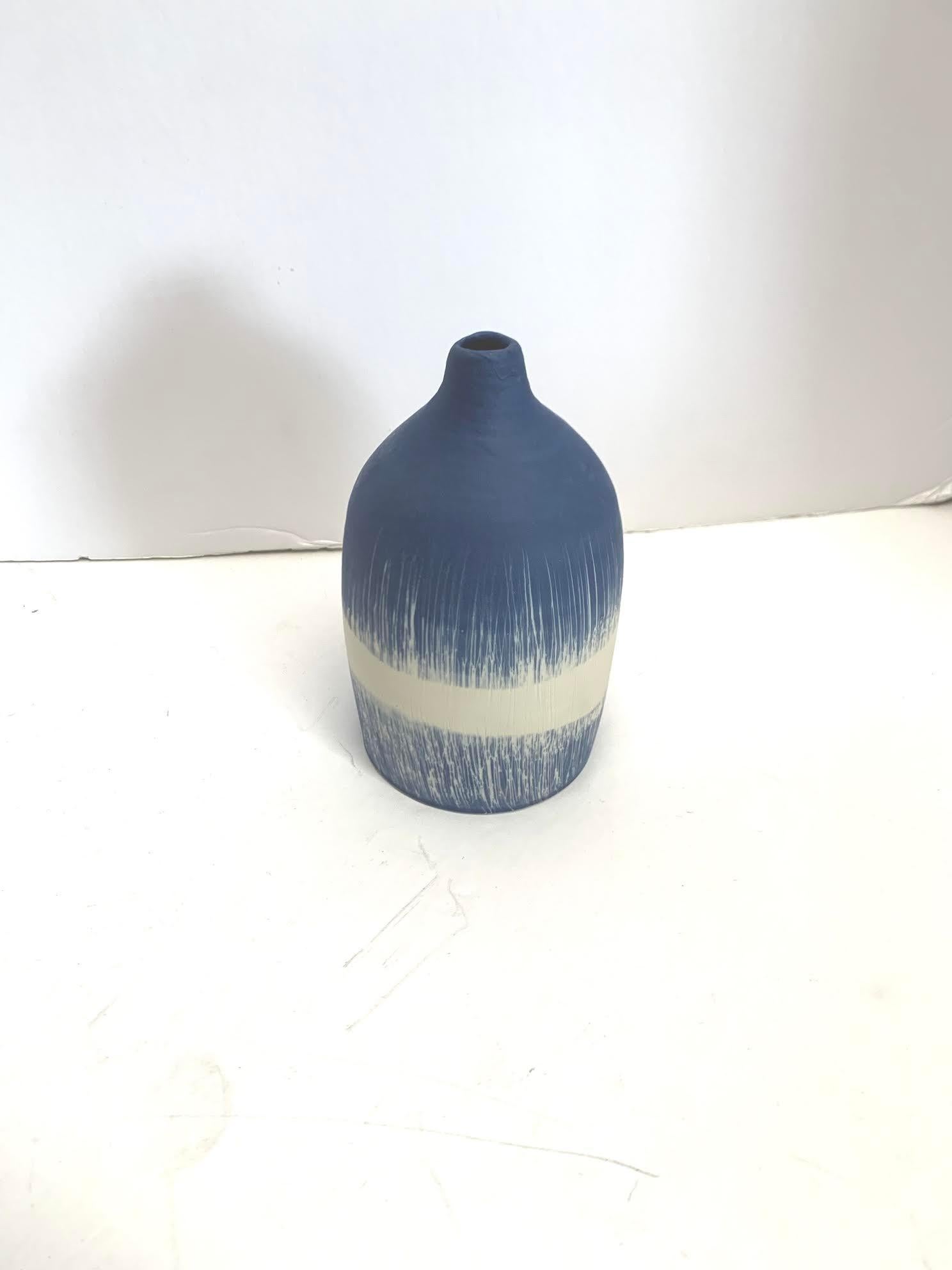 Contemporary Italian hand made ceramic blue ground vase with vertical grass blades and white band design.
Matte glaze.
Part of a large collection of blue and white diminutive vases.
See image #5.