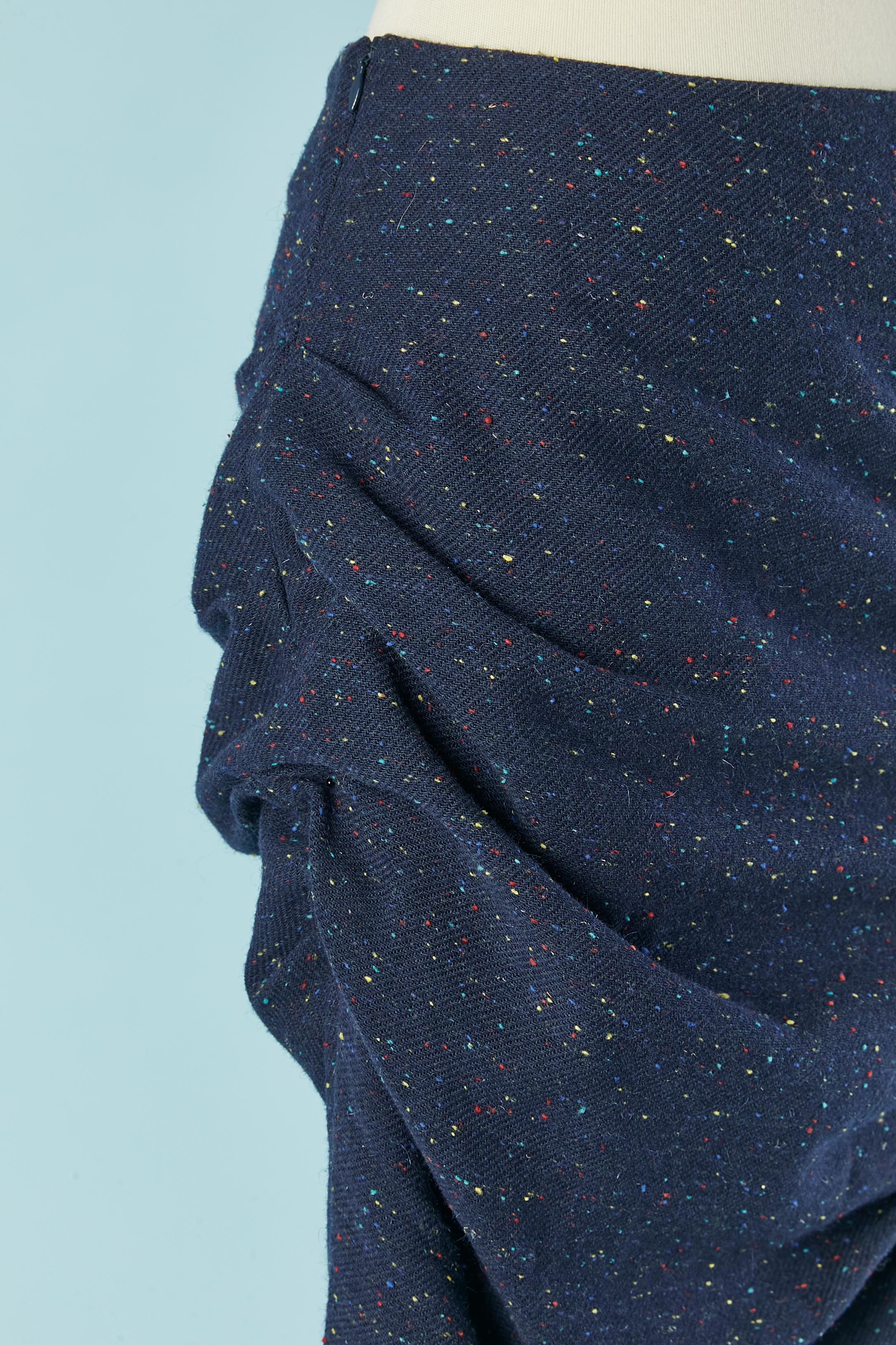 Gonna in lana chiné blu intrecciata sul lato sinistro. Composizione del tessuto principale: 55% lana, 45% poliestere. Composizione della fodera: 68% acetato, 32% poliestere. 
Chiusura con zip sul lato destro. 
TAGLIA 36 (Fr) S 