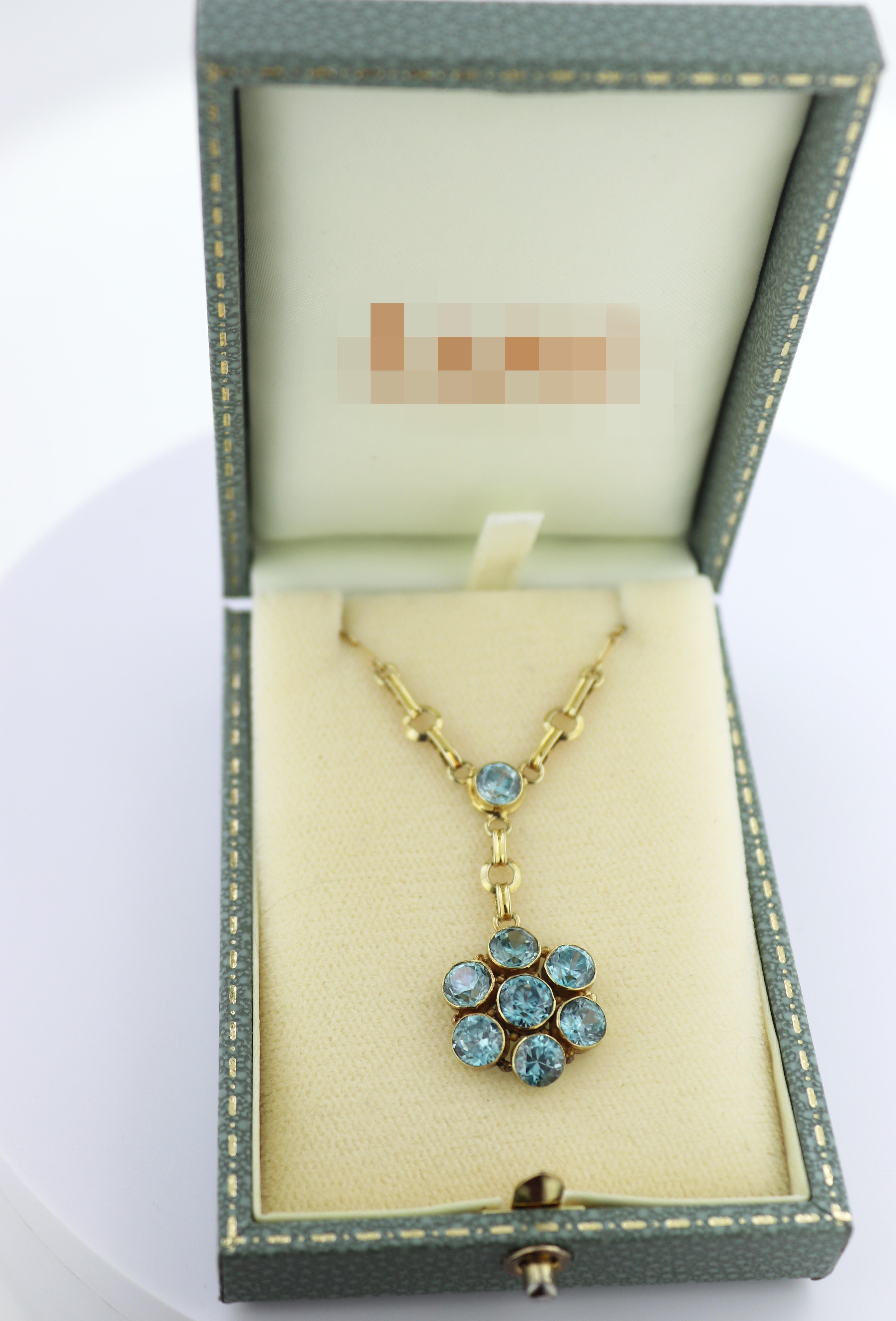 Featuring (8) round-cut blue zircons, surmounted by (1) round-cut blue
zircon, 6.30 cts., tw., each bezel set in a 14k yellow gold flower drop,
suspended from a 14k yellow gold rectangular and round link chain,
completed by a spring ring clasp