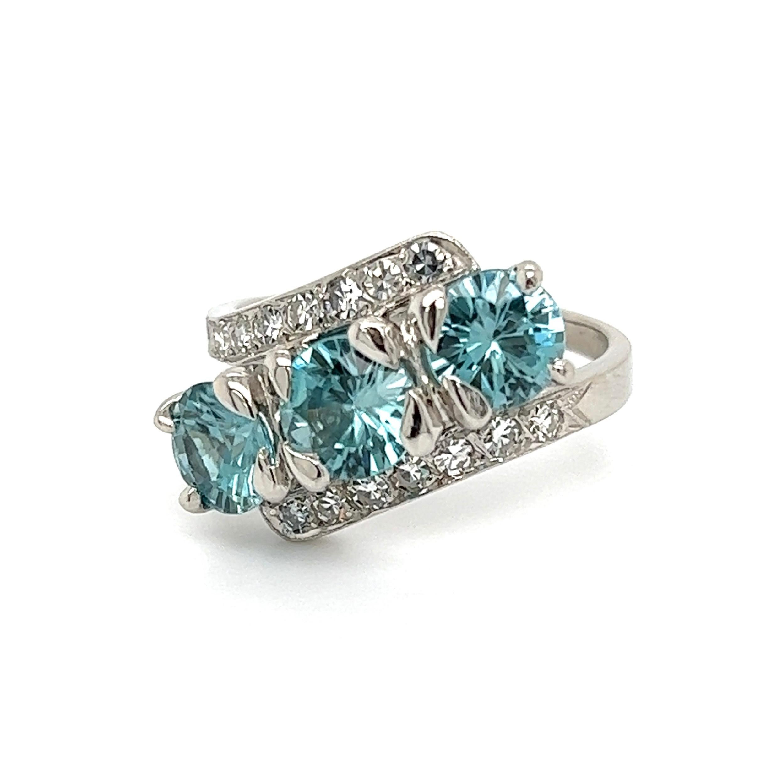 Simply Beautiful! Finely crafted Three Stone Blue Zircon and Diamond Ring. Hand set 3 Blue Zircons weighing approx. 4.55tcw, enhanced with Diamonds, weighing approx. 0.50tcw. Ring size: 6.5, we offer ring re-sizing. Dimensions 0.93” l x 0.76” w x