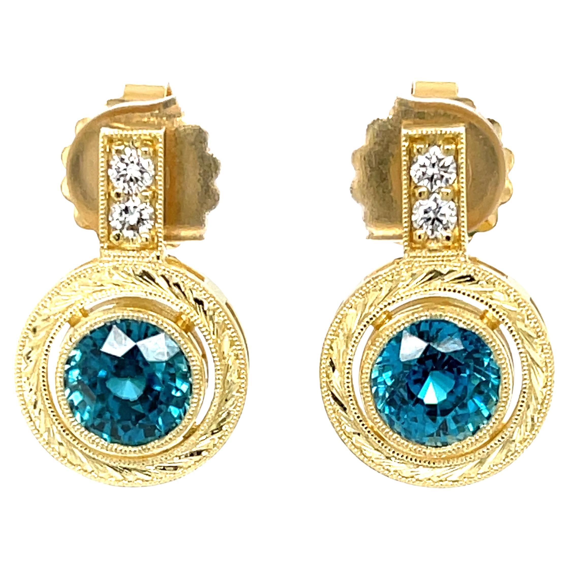 These gorgeous drop earrings feature a stunning pair of 5.50mm blue zircons set with diamonds in 18k yellow gold. Weighing a total of 5.52 carats, these gems are truly impressive with their electric blue color and extraordinary brilliance. They are