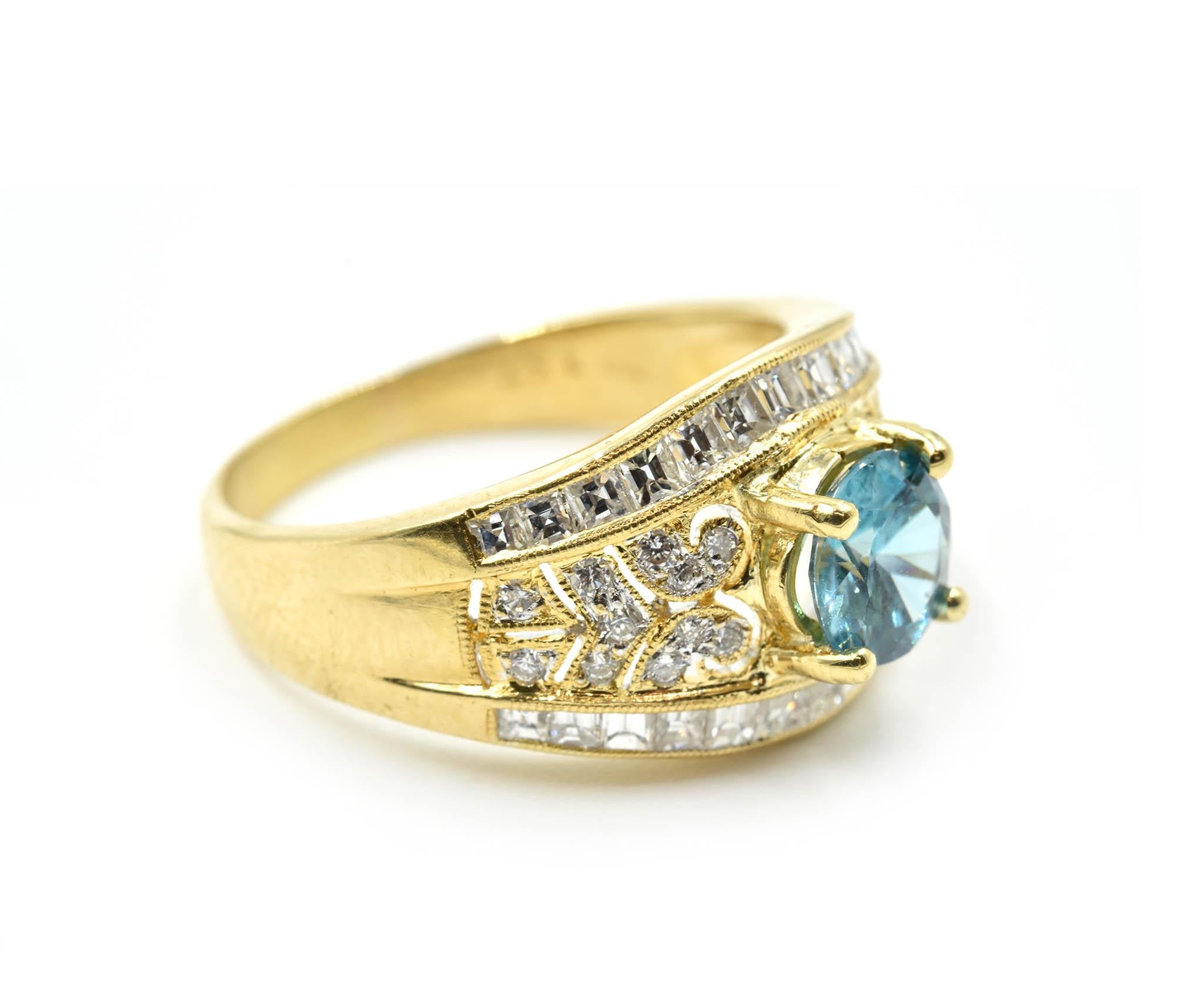 Designer: custom design
Material: 18k yellow gold
Blue Zircon: one round cut 1.40 carat blue zircon
Diamonds: 48 round and princess cuts = 0.74 carat total weight
Dimensions: ring top is a ½-inch long and ¾-inches wide
Ring Size: 8 (please allow two