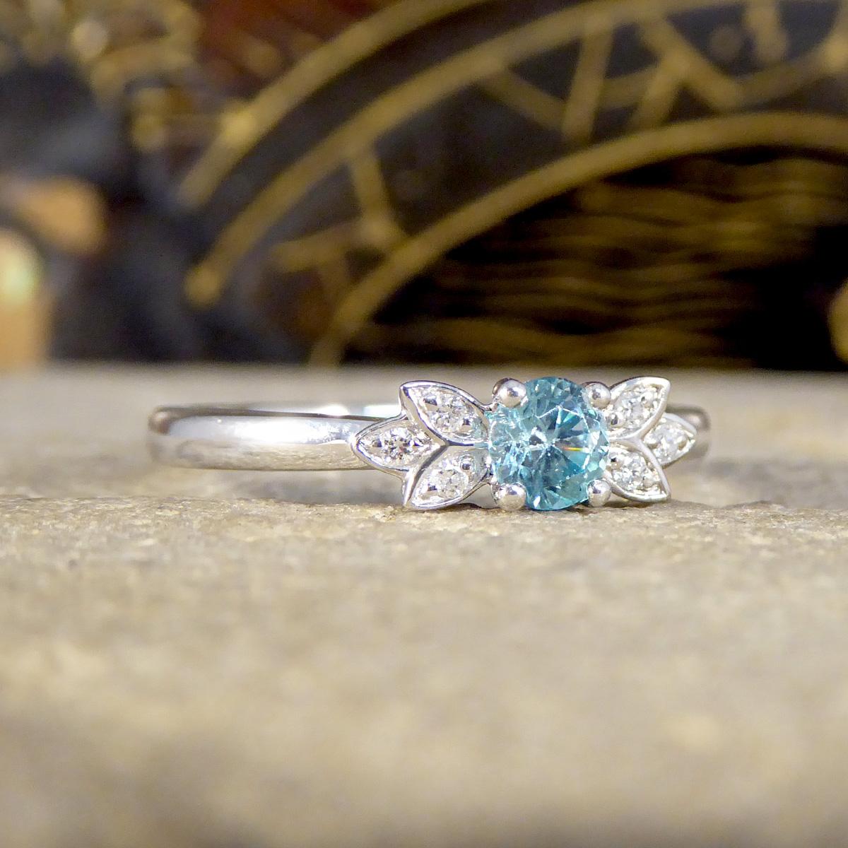 At the heart of this beautiful and dainty ring, a vibrant blue zircon dazzles with its deep, oceanic hues, reminiscent of the most serene waters. Surrounding this central gemstone, diamonds are meticulously set to form delicate butterfly wings,