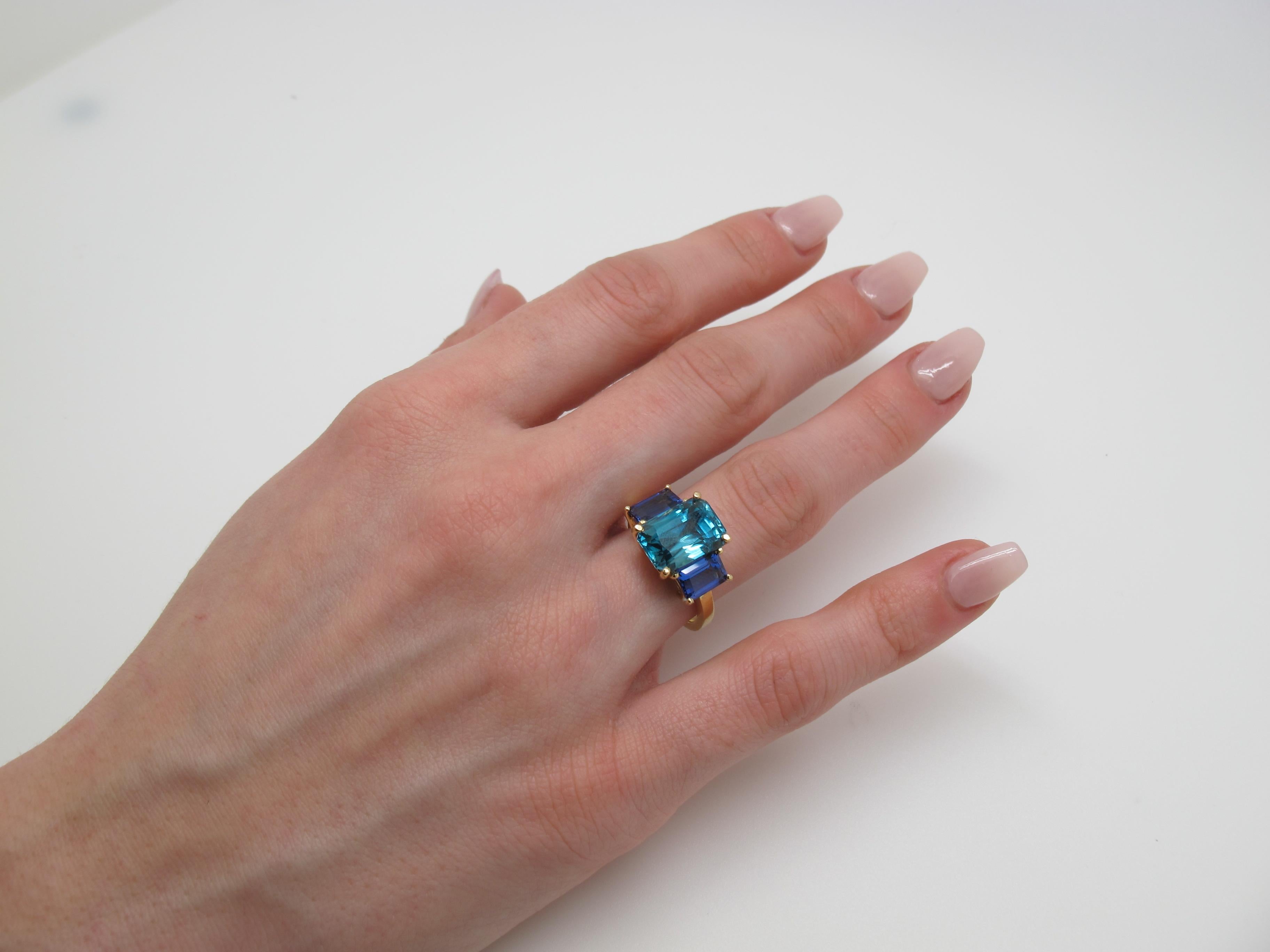 A modern twist on he classic 3-stone ring! Here, we pair a brilliant, natural Blue Zircon (11.45x8.16mm/7.65cts) with Tanzanites (7x5mm/2.20cts tw) to form a beautiful color pairing.

Handmade by our jewelers in Los Angeles.