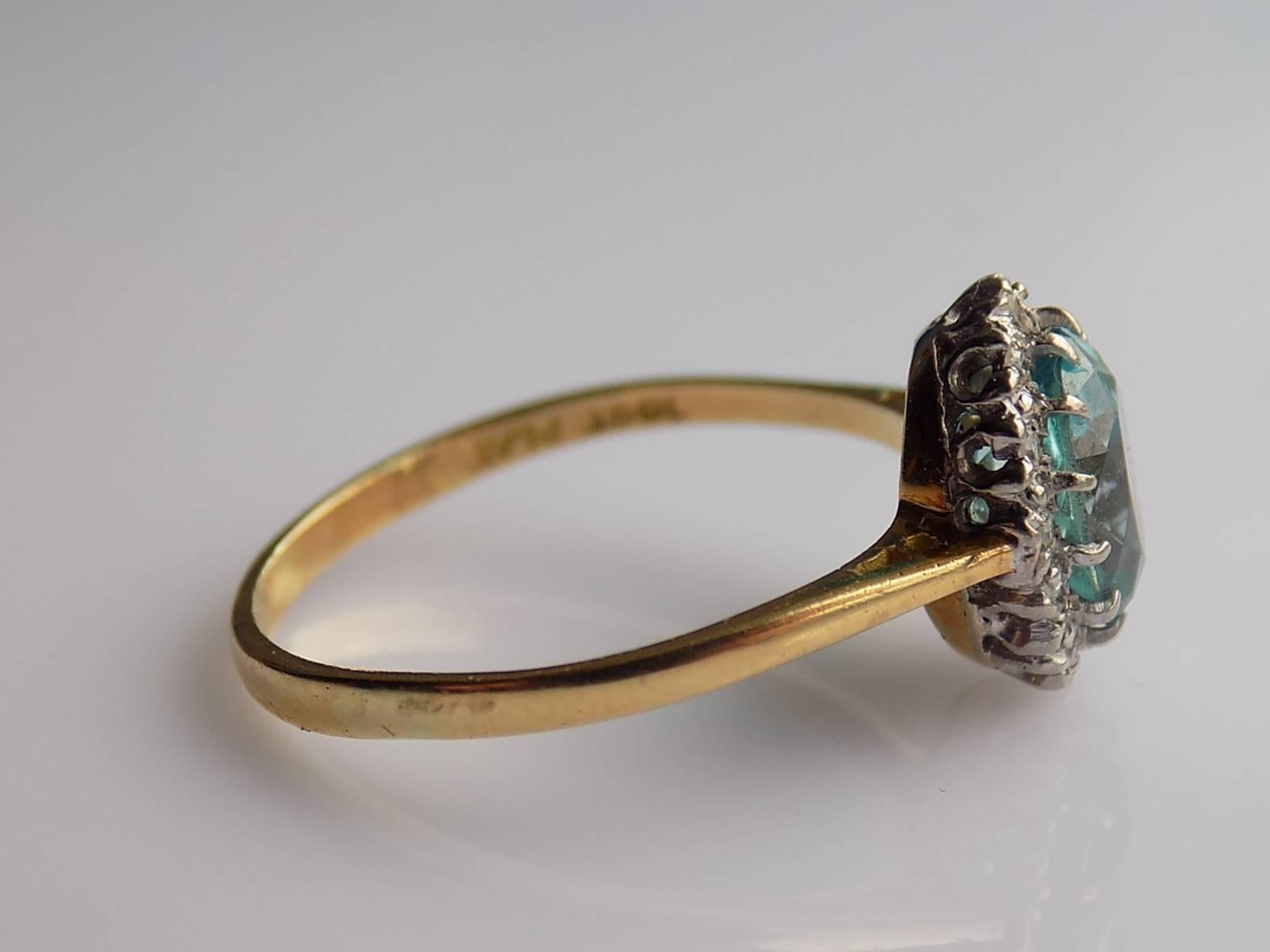 A Lovely Art Deco c.1930s 18 Carat Gold, Platinum, Blue Zircon and Diamond cluster ring. English origin.
Height of the face 11mm.
Zircon 8mm x 6mm approx 2 Carat.
Weight 2.9gr.
Size O UK, 7.5 US
Marked: 18CT PLAT for 18 Carat Gold and Platinum.