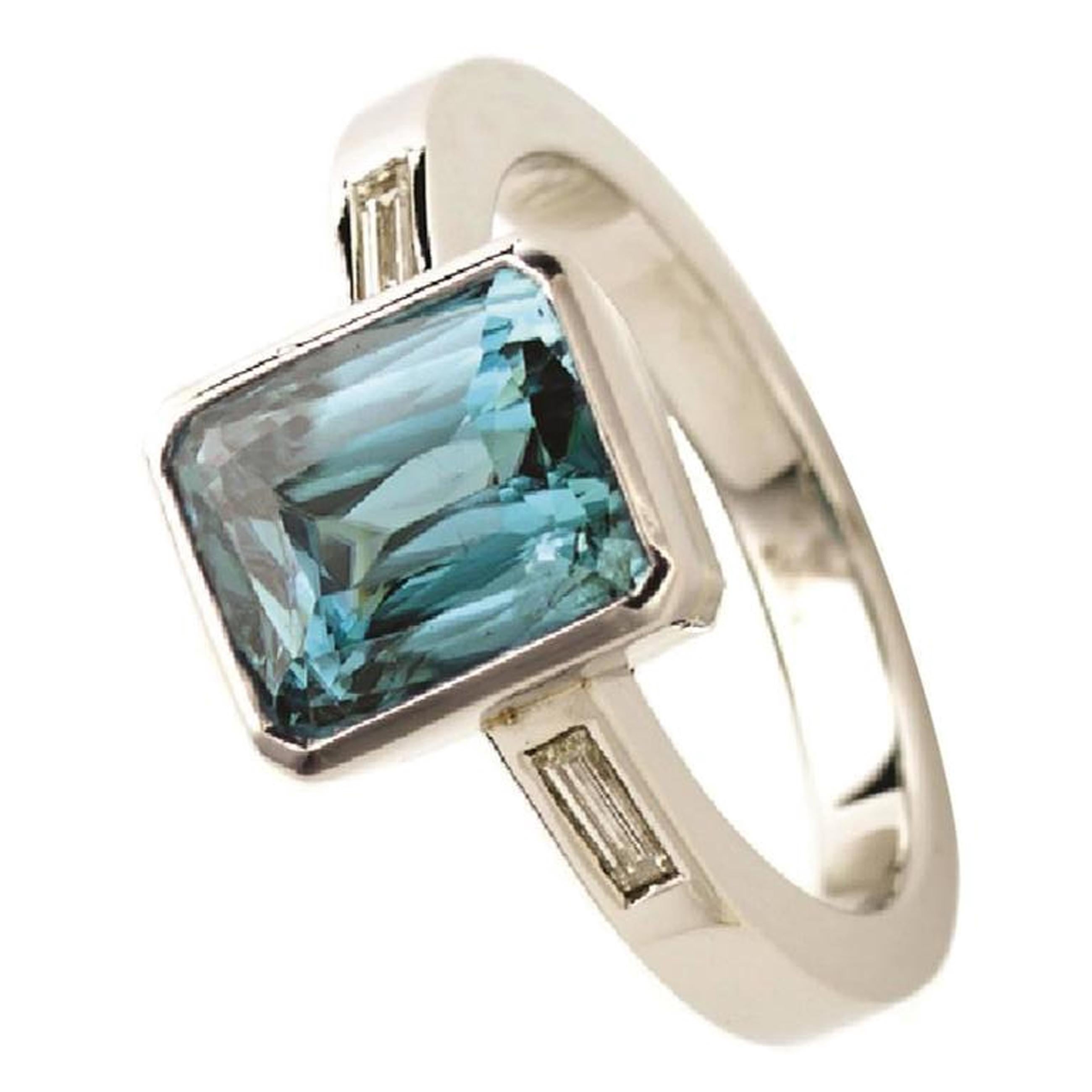 Natural emerald cut Blue Zircon 3.4 carats) with two agate cut Diamonds on the shoulders set in 9kt white gold.
Stone 8.48 x 6.95 mm
Ring size:  M 1/2