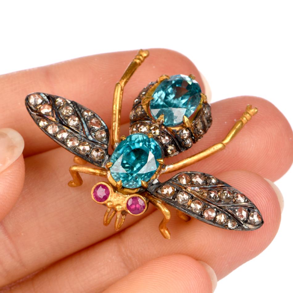 This whimsical bug brooch is crafted in silver guild gold, weighing 7.6 grams and measuring 42mm wide (max) x 32mm long. Depicting a fly like bug, the body is represented by 2 prong set, oval shaped blue Zircons, weighing approximately, 5.80 carats.