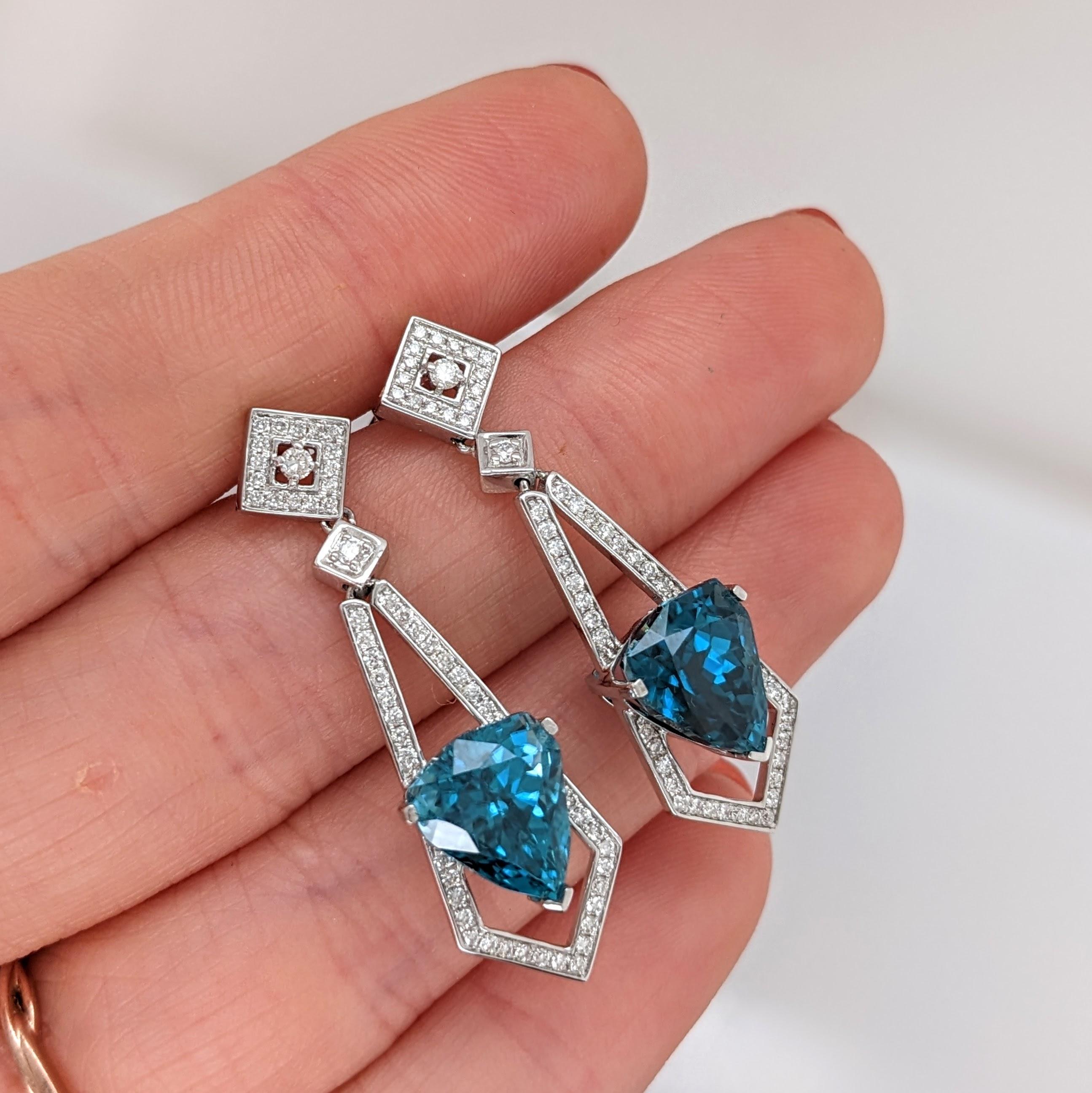These beautiful drop earrings feature a pair of 12.75 carat weight Blue Zircon gemstones with natural earth mined diamonds set in solid 14K gold. These Blue Zircon earrings make a lovely December birthstone gift for your loved ones!