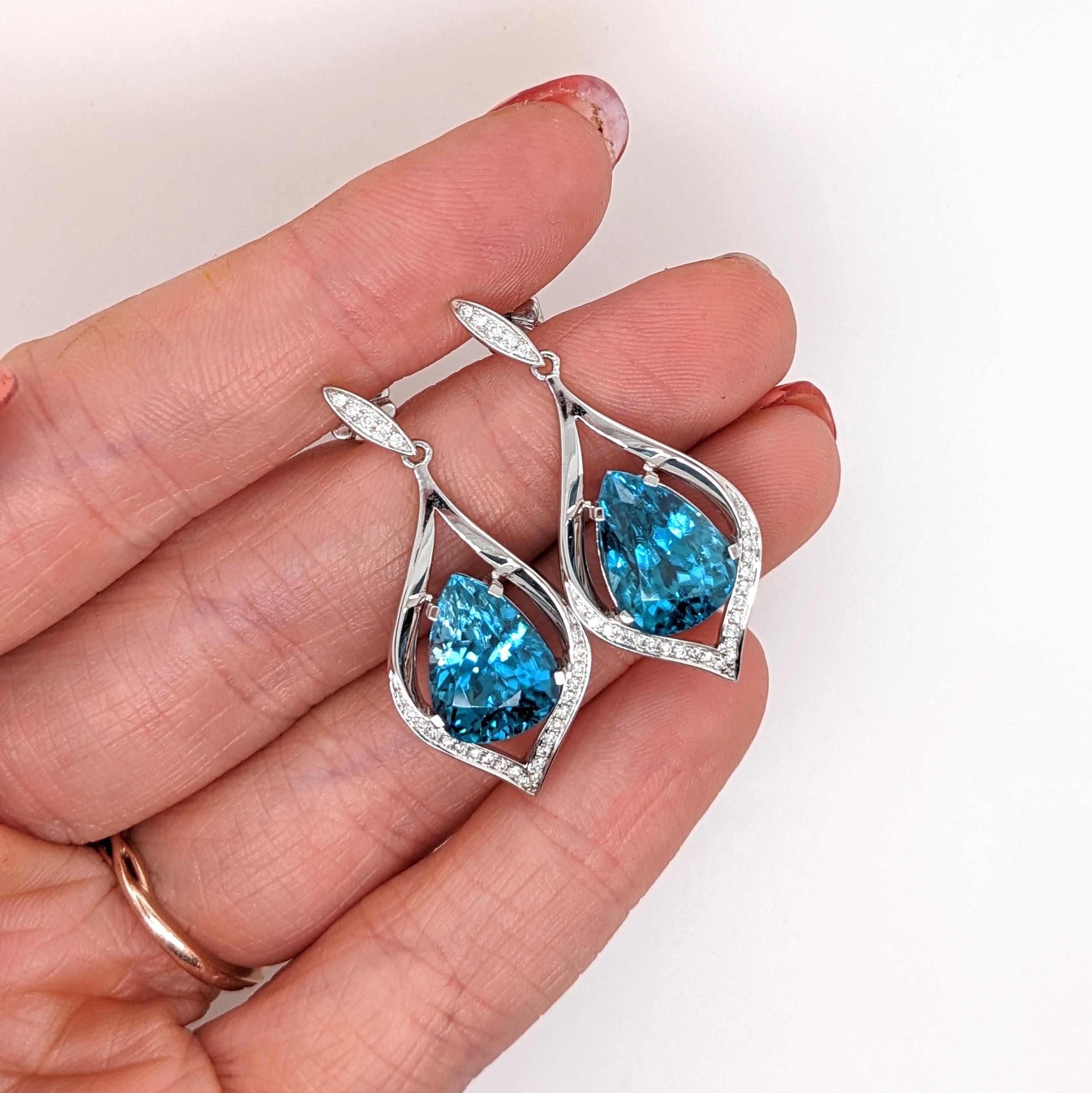 These beautiful drop earrings feature a pair of 17.94 carat weight Blue Zircon gemstones with natural earth mined diamonds set in solid 14K gold. These Blue Zircon earrings make a lovely December birthstone gift for your loved ones!
