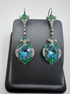 Orecchini pendenti in platino con diamante smeraldo e zircone blu