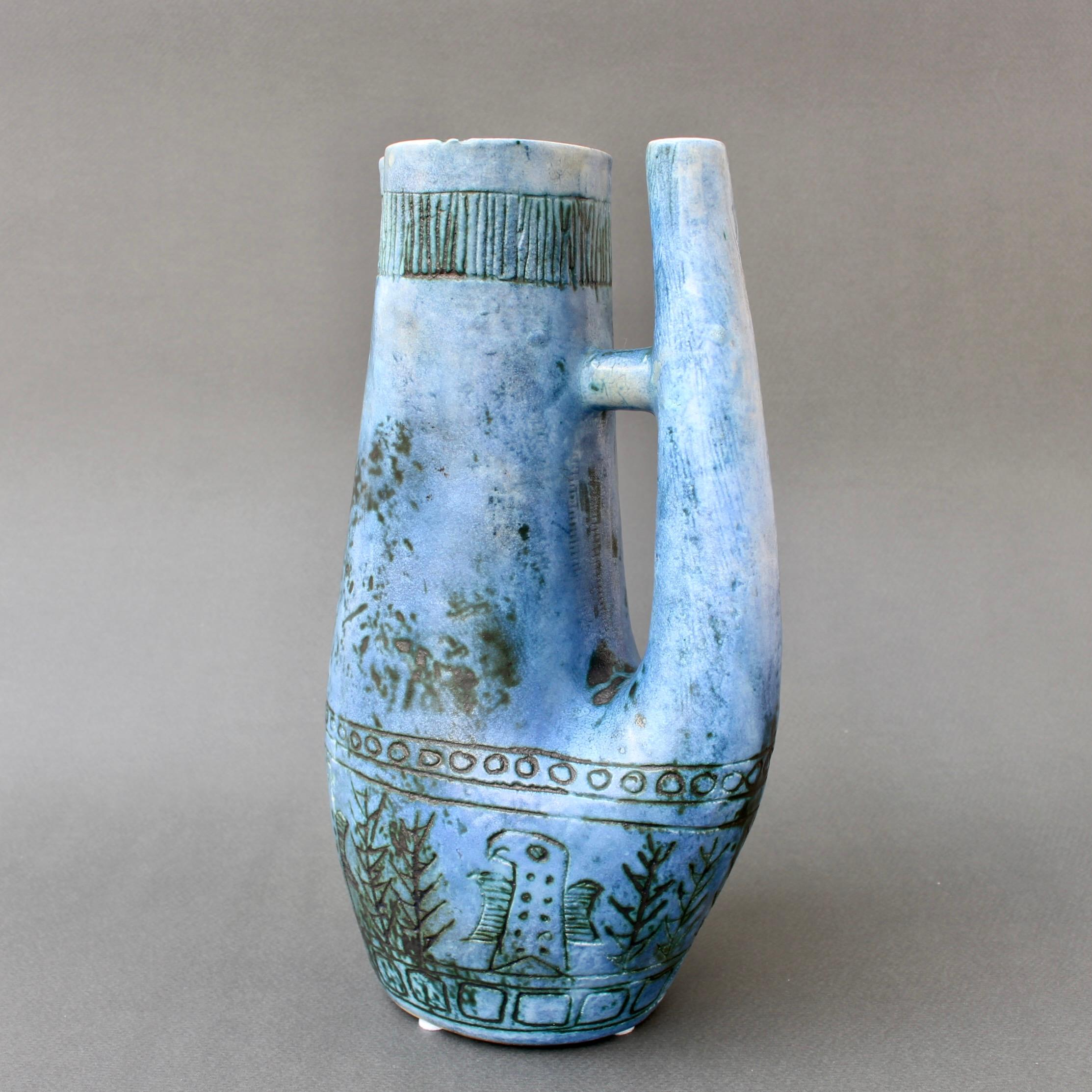 Dekorative Vase aus blauer Keramik (ca. 1950er Jahre) des französischen Keramikers Jacques Blin. Die Vase ist in einem gedämpften Blau mit der für Blin typischen nebligen Glasur gehalten. Sie ist mit einem Fries aus stilisierten Vögeln und