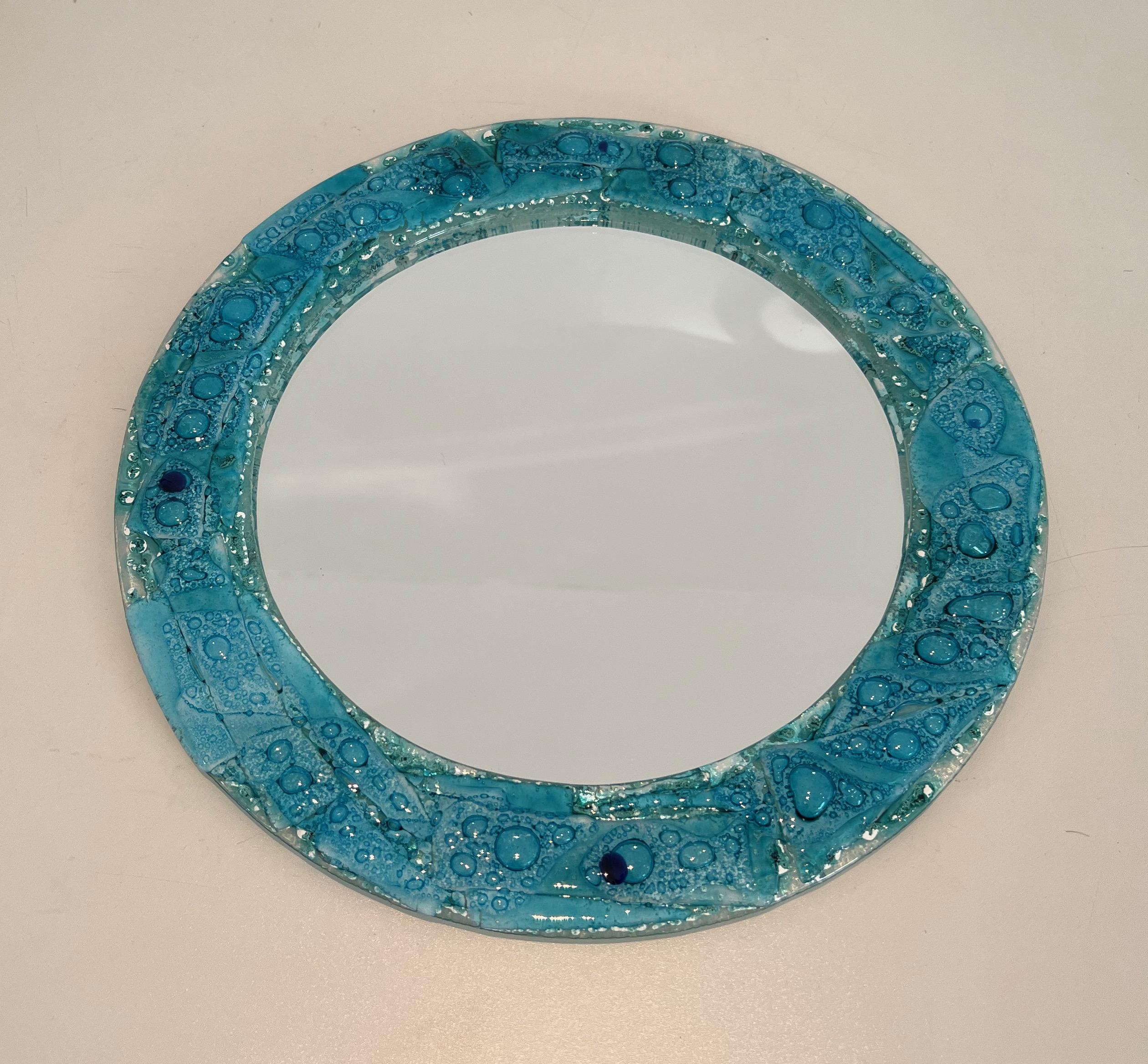 Ce très beau miroir décoratif est composé d'un cadre rond en verre bleuâtre. Il s'agit d'un ouvrage français. Circa 1970