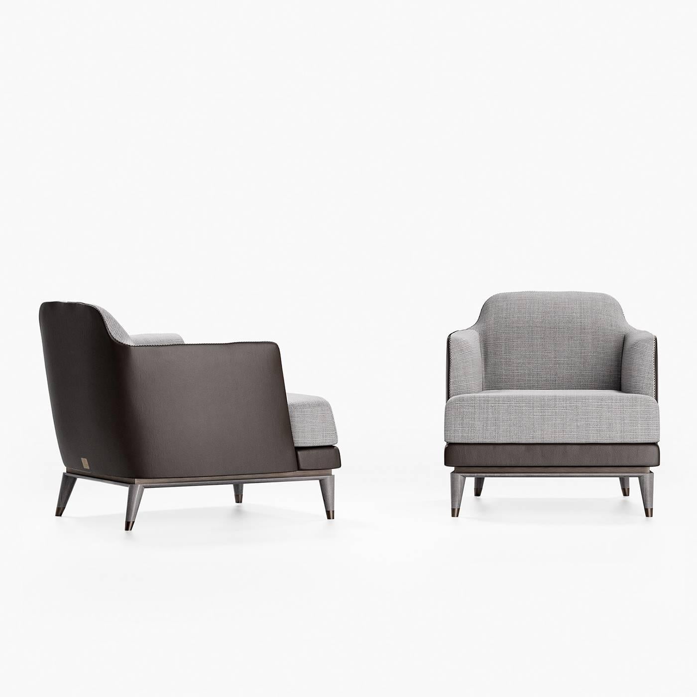 Simple yet bold, clean lines and block colors characterize this timeless occasional armchair. Featuring a deep seat and closed armrests, this elegant piece is upholstered with gray fabric on the inside and black leather on the outside and base,