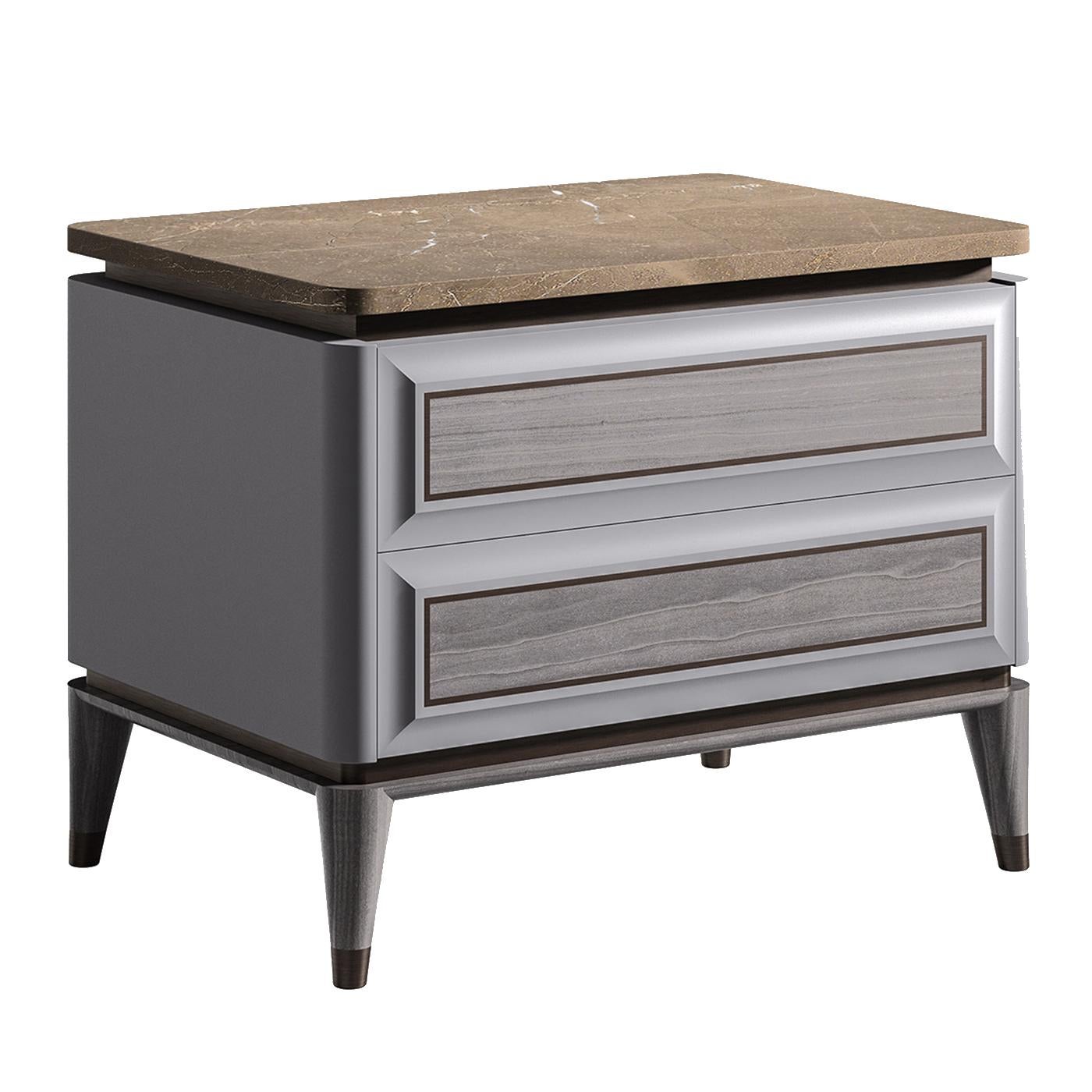 A Classic Silhouette with contemporary flair, this night table features a sleek wood frame with an elegant gray finish and two drawers with raised front panels and brown profiles that recall the metal ferules of the four conical feet. The striking