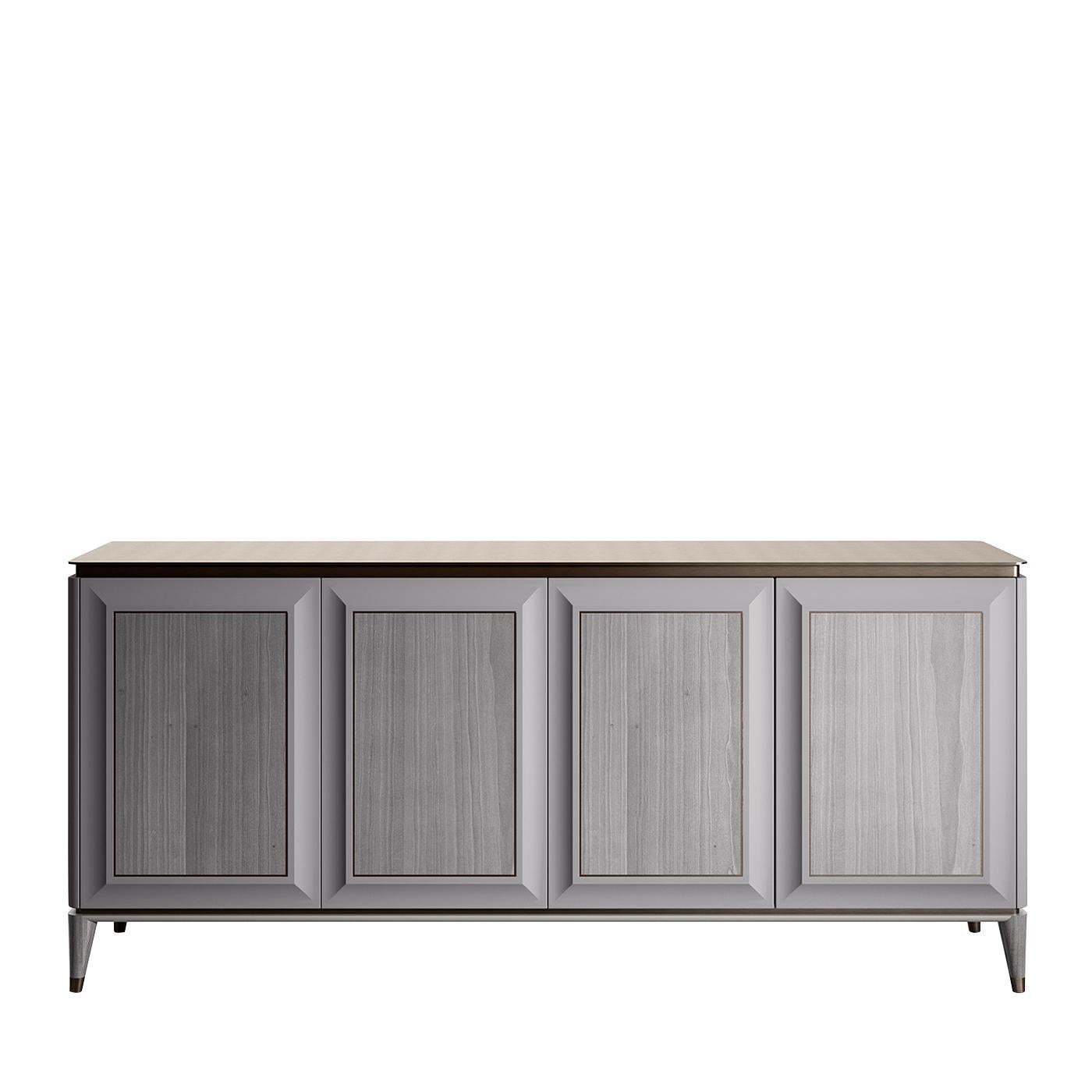 Clever contours and functional details define this elegant sideboard in grey lacquered wood with a velvet-like finish that floats on four angled, tapered legs. Four veneered doors raised on a bevelled frame are accented with a delicate brown profile