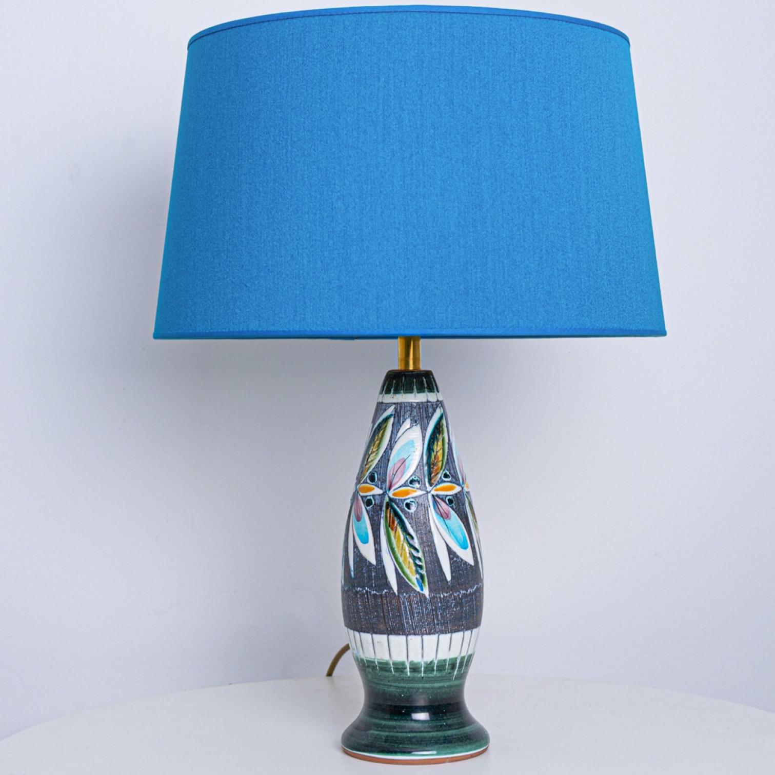 A rare ceramic table lamp, made by Tilmans Zweden 1970s. Sculptural piece, made of handmade ceramic with a new custom made matching lamp shade. The base has a beautiful floral pattern with vibrant colours.

The lamp is in perfect vintage condition.