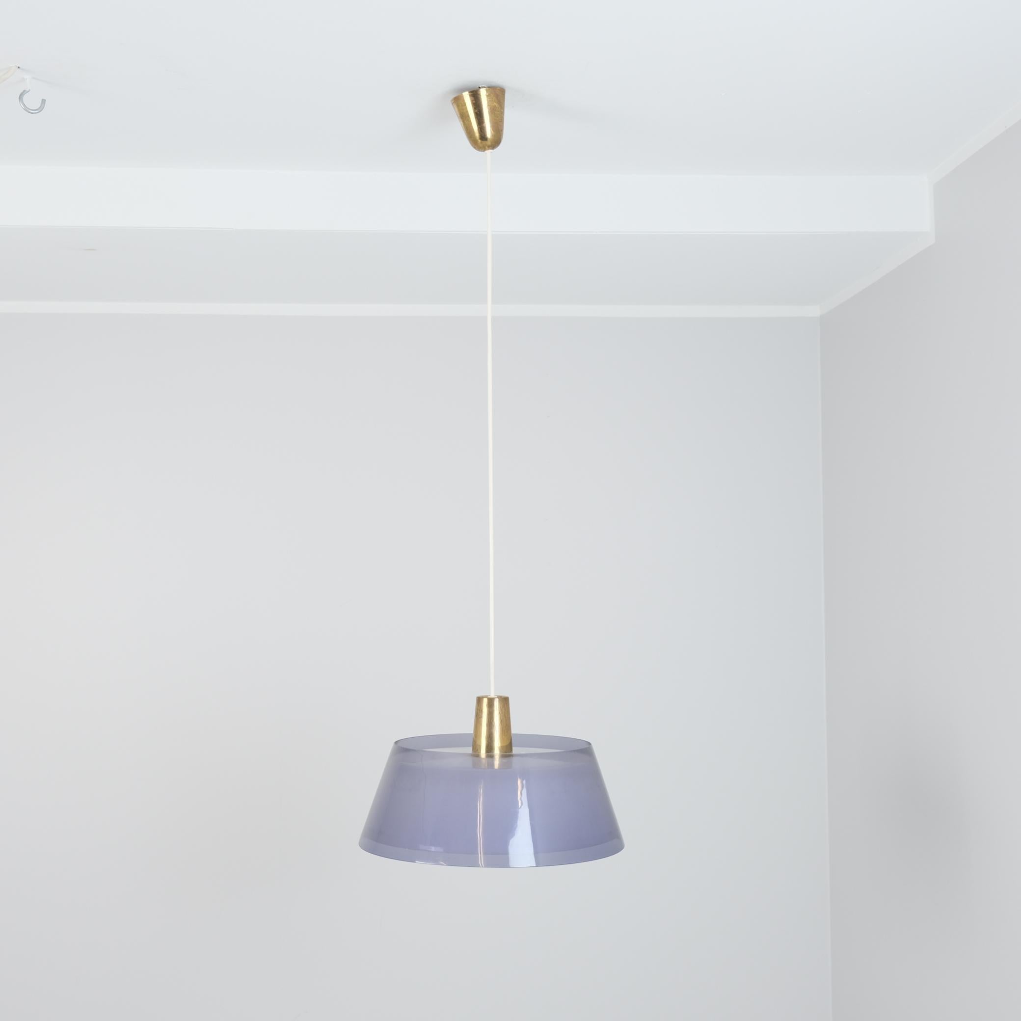 Magnifique pendentif modèle 64-401 du designer finlandais Yki Nummi fabriqué par Orno pour Stock-Orno. Cette lampe moderniste présente deux abat-jours en plexiglas superposés et suspendus par la Corde et reliés par des pièces en laiton. Les