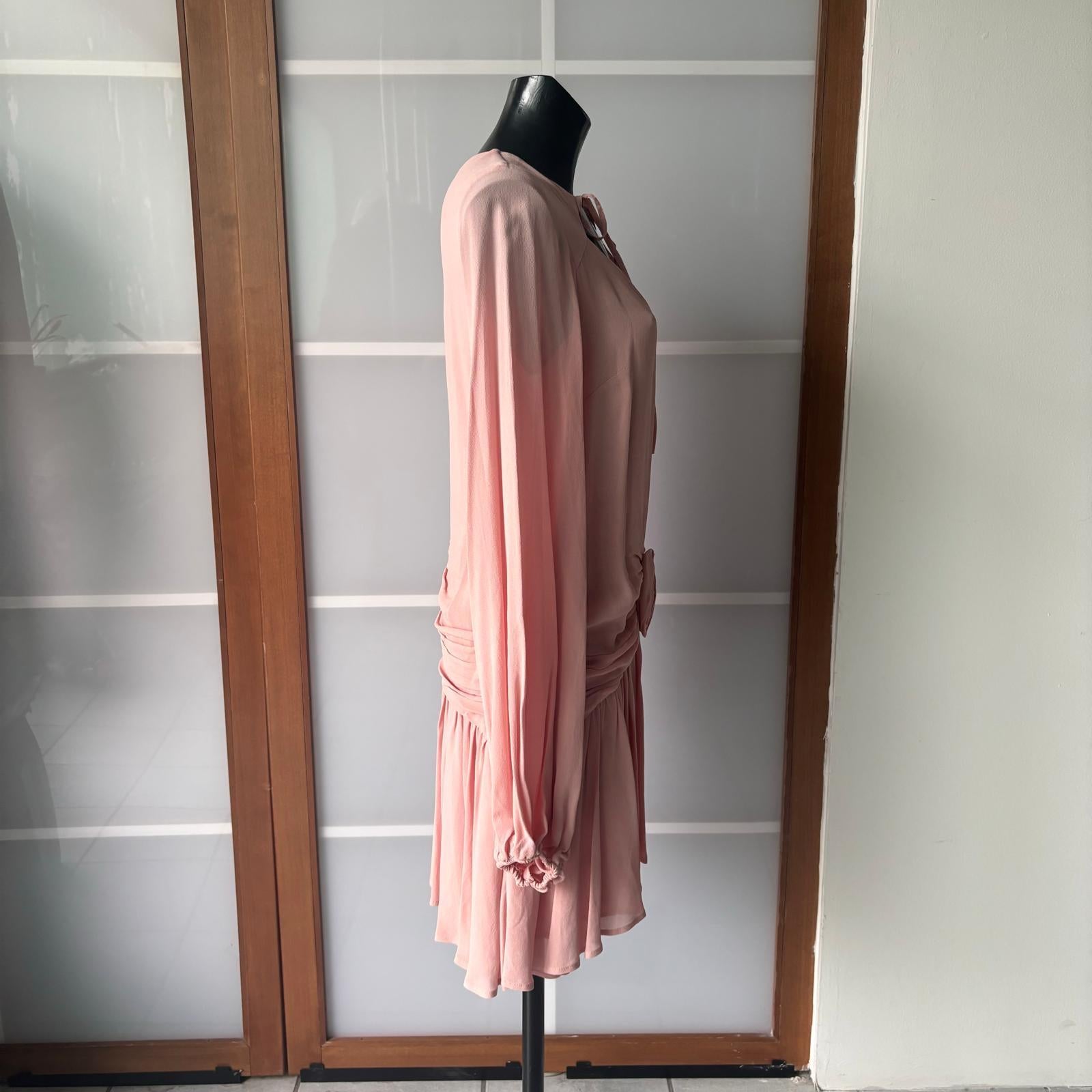 Elegantes, kurzes Blumarine-Kleid, made in Italy, das sich durch ein feminines und raffiniertes Design auszeichnet.
Das Modell ist aus einem hellen, puderrosa Stoff gefertigt und hat markante Details: einen Ausschnitt mit einer dünnen Spitze am