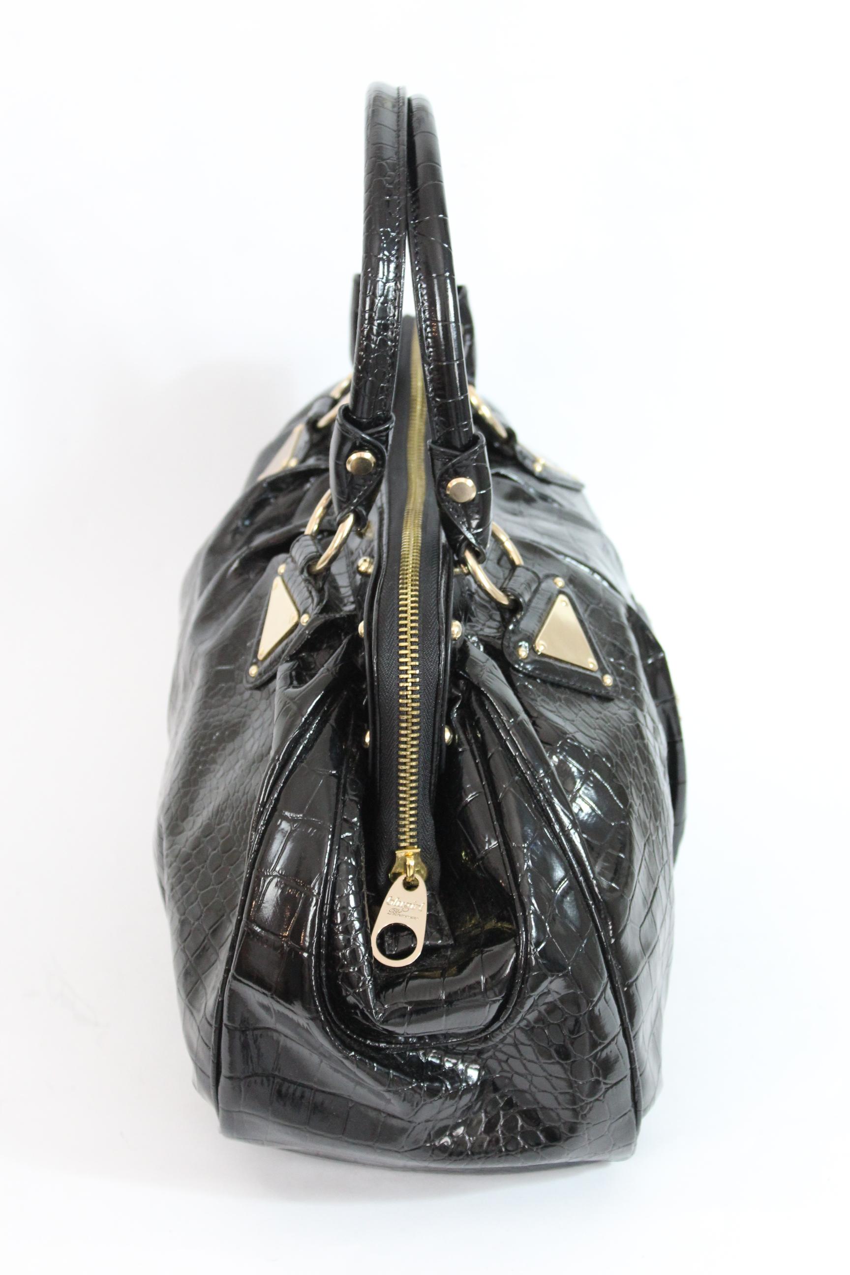 Blumarine Blugirl line 90s vintage bag. Large handbag, black with gold-colored details, crocodile print. Zip closure, patent fabric. Made in Italy. Excellent vintage condition. The dustbag is present.

Height: 28 cm
Width: 43 cm
Depth: 11 cm
Handle