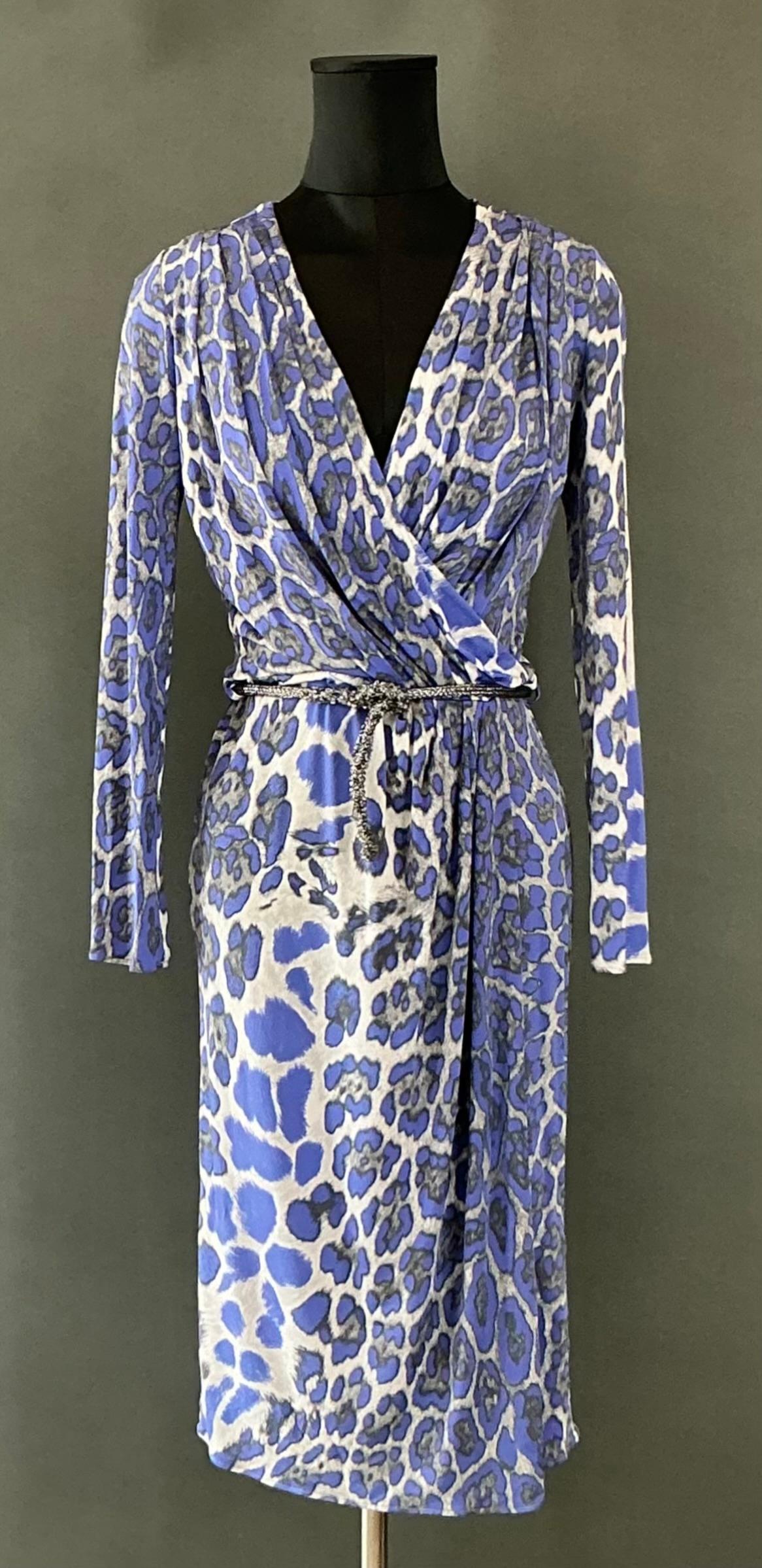 The Blumarine Rusched Leopard Dress is likely a luxurious and feminine piece from the Italian fashion house Blumarine, known for its romantic, floral-inspired designs and delicate details. Blumarine often combines classic femininity with